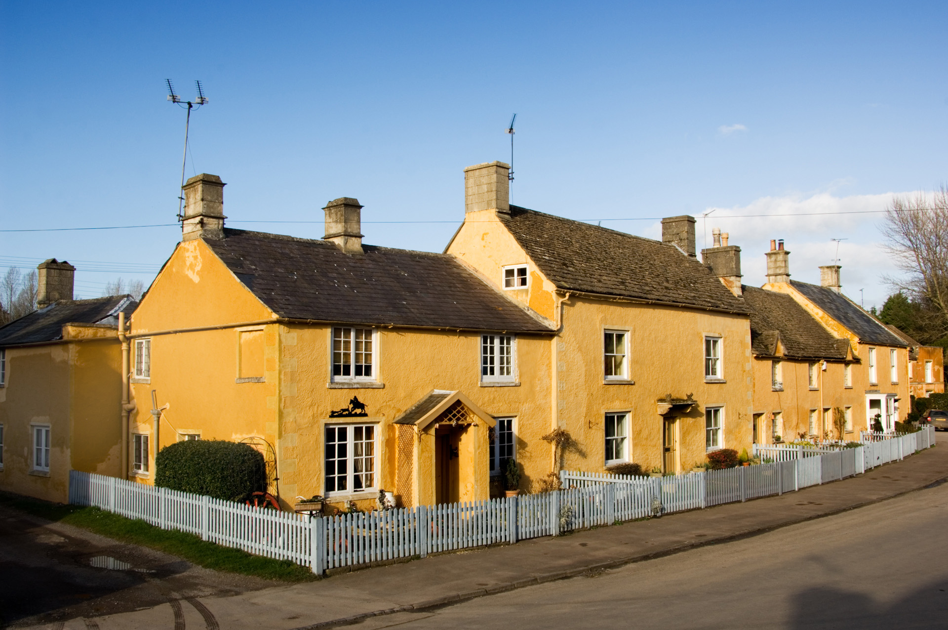High Street, Badminton, Gloucestershire.  General view of cottages with uniform limewash.