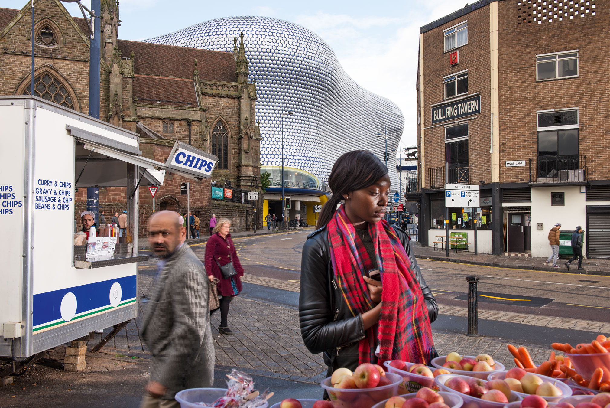 A market scene in Birmingham with a mixture of old and new building styles in the background.
