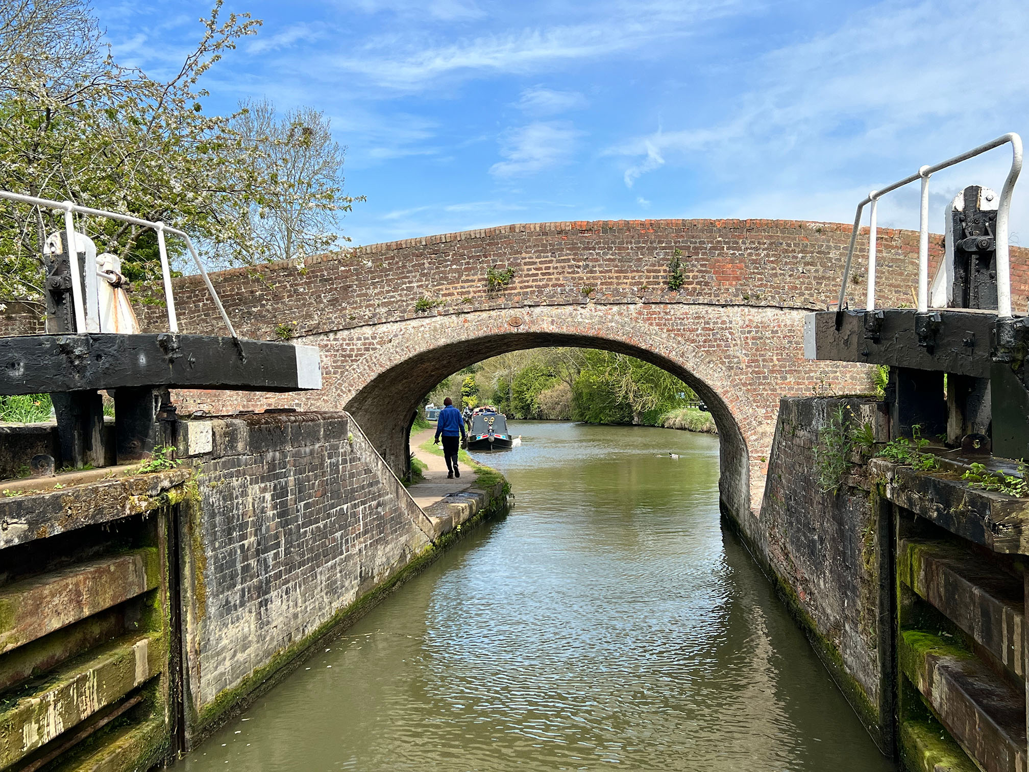 Bridge over a canal. Canal boat within a body of water.