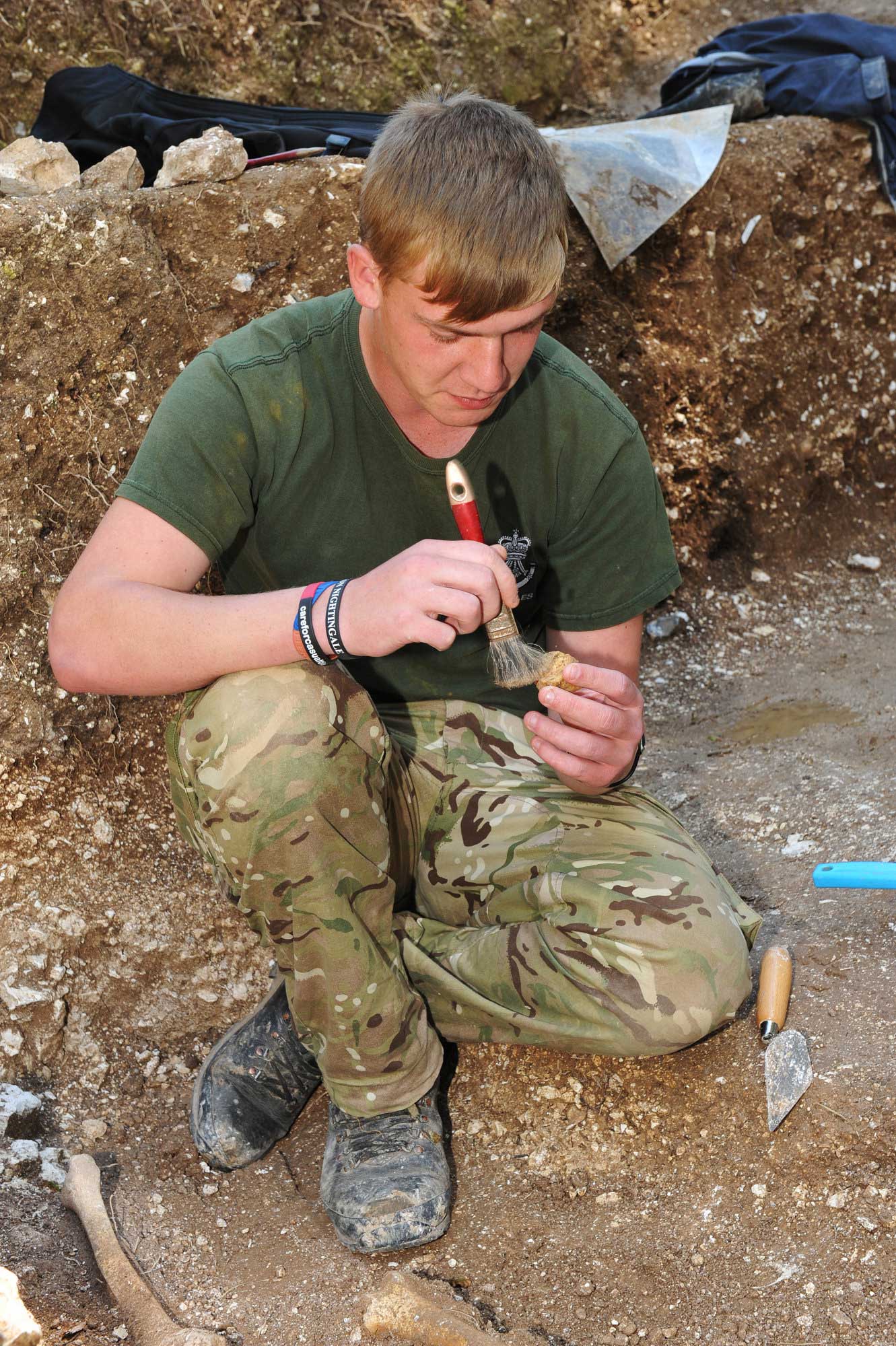 A young soldier working o nan archaeological excavation