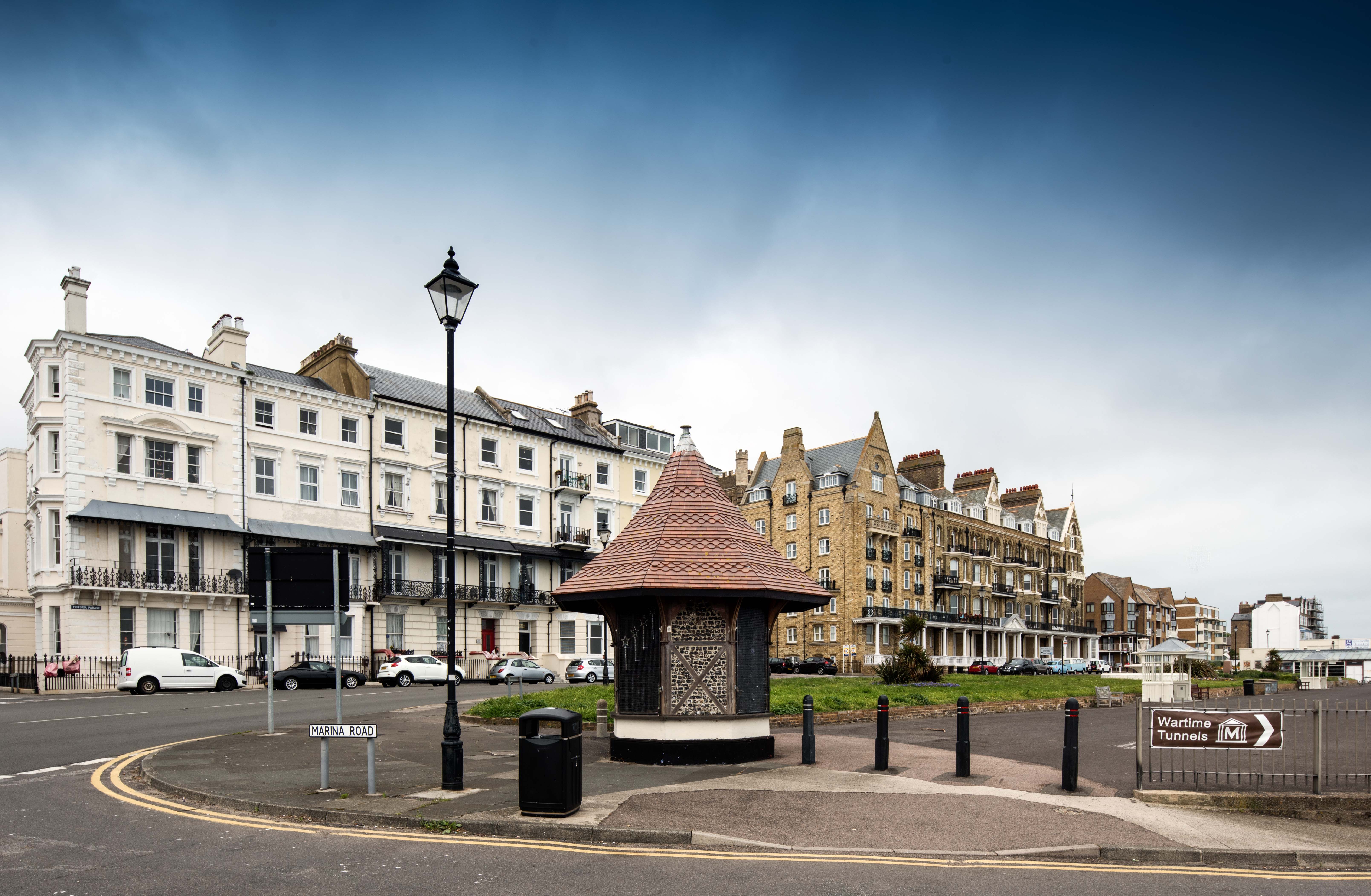 Timber framed octagonal kiosk on Ramsgate seafront with terrace of buildings in the background
