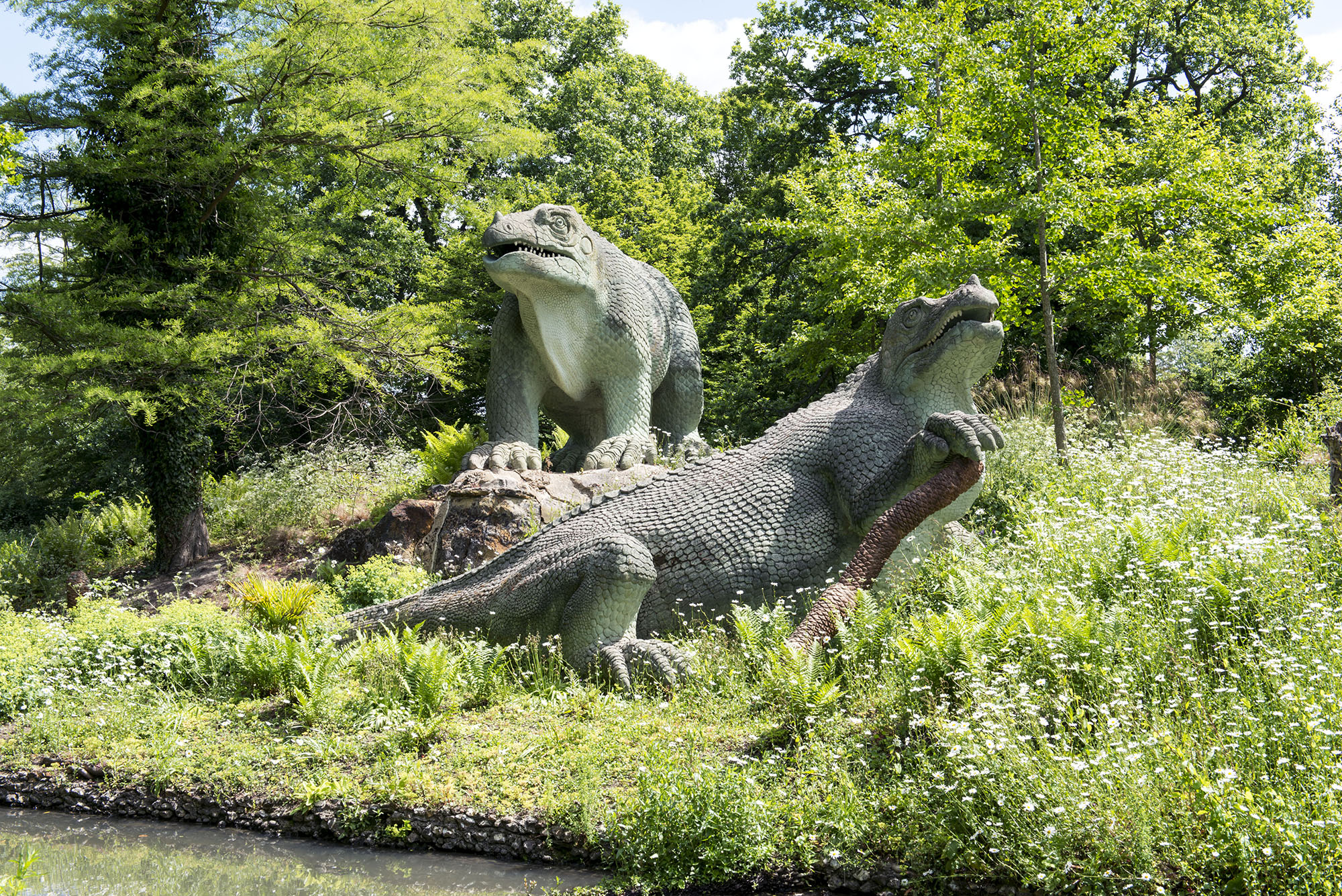 Two Iguanodon on a grassy bank