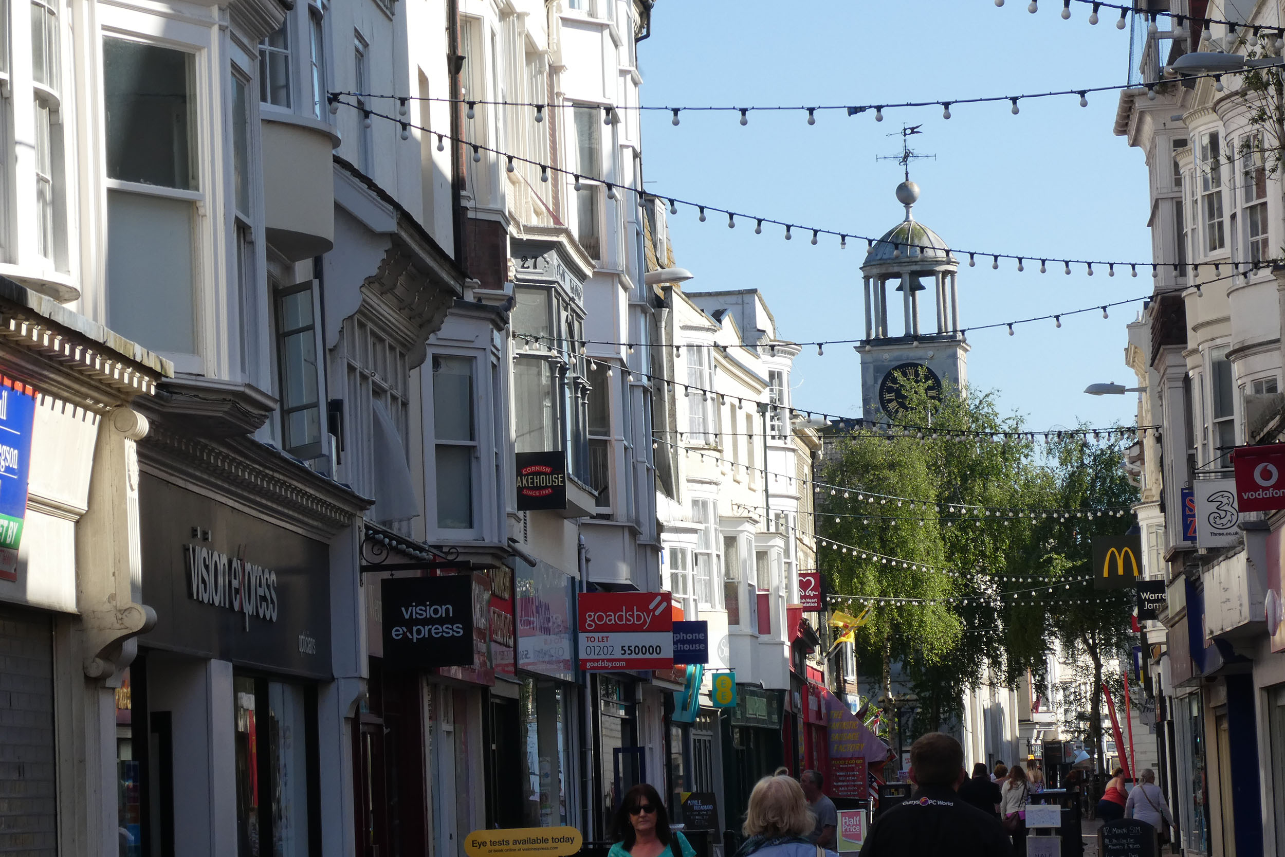 Image of a shopping street in Weymouth showing shops and to let signs.