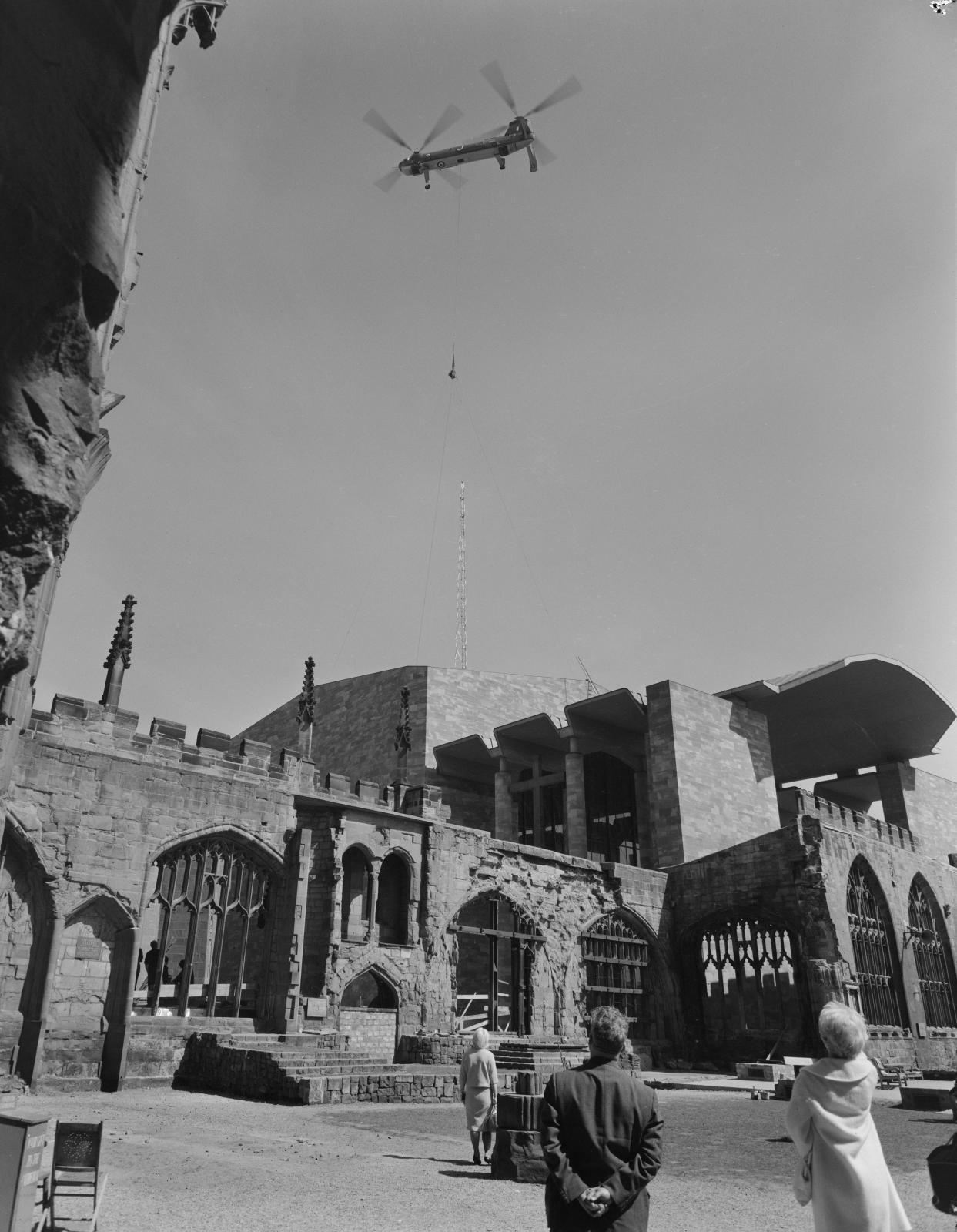 Looking up from the ruins of the old Coventry Cathedral towards a RAF Belvedere helicopter lowering the 80ft bronze spire on to the roof of the new cathedral