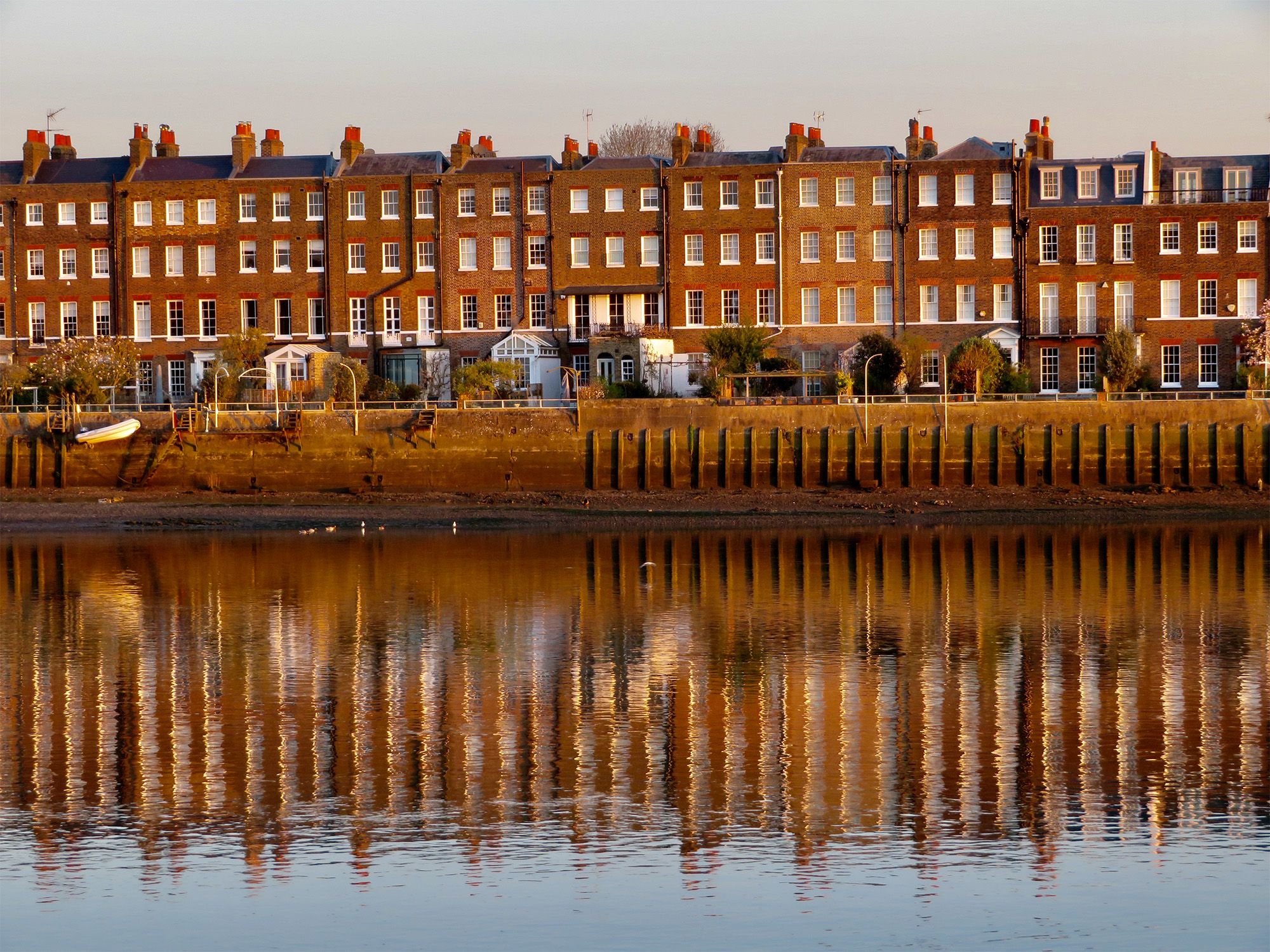 Row of terraced housing reflected in the river