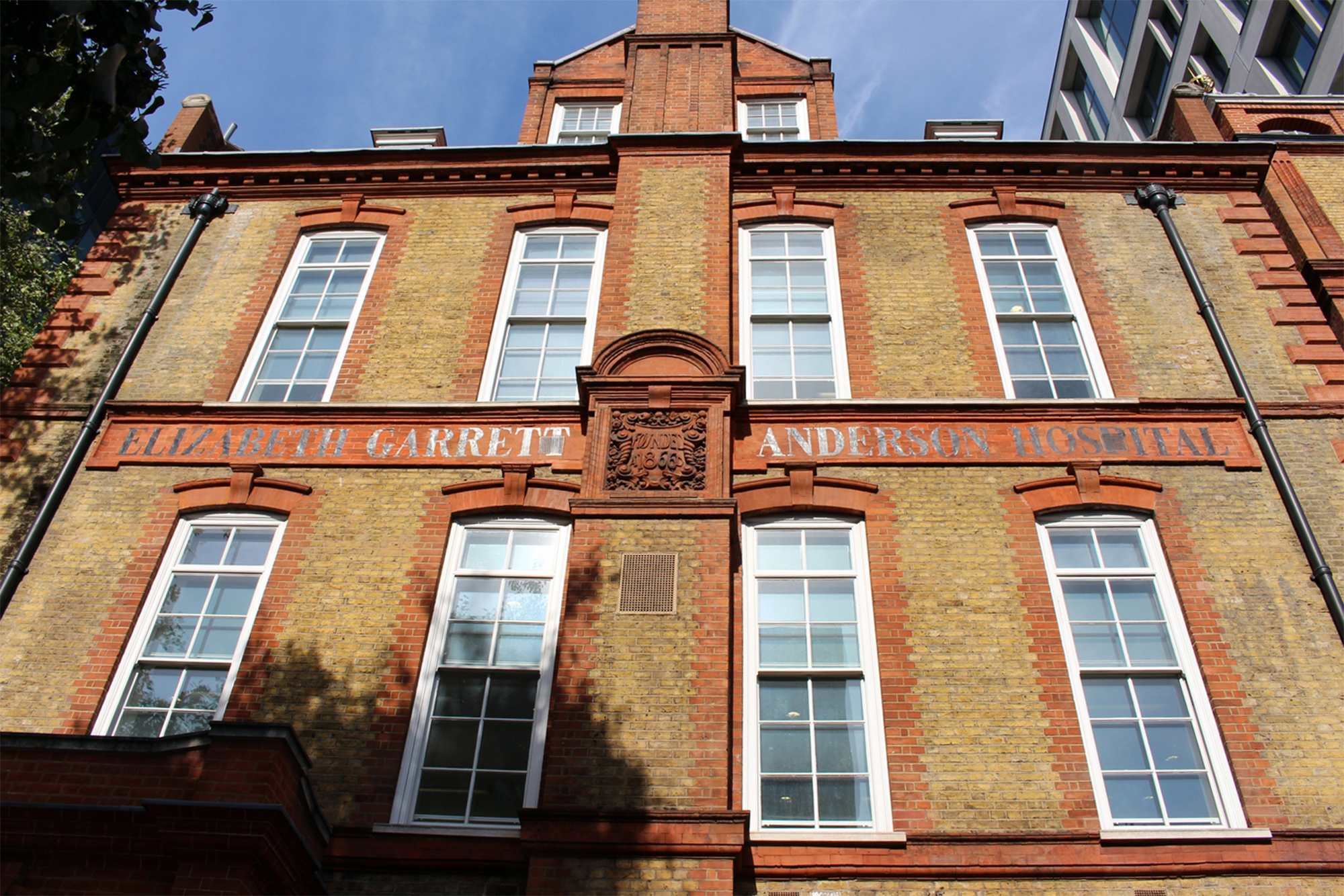 Red brick building with sash windows and the words Elizabeth Garrett Anderson Hospital written halfway up the front facade.