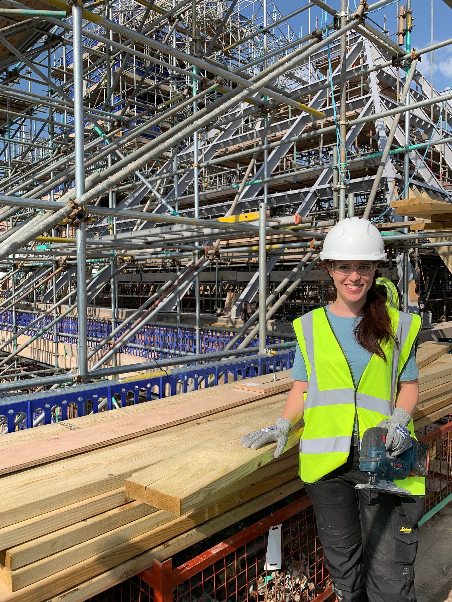 Rosie, wearing hard hat and high viz jacket, completed a carpentry placement working on the Kiln roof