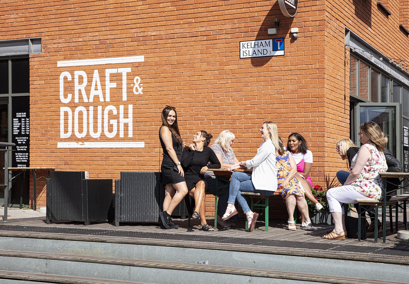 Customers enjoying the sunshine at Craft and Dough at 1a Kelham Square in Sheffield's Kelham Island, Sheffield. The conservation area has been rescued and removed from the Heritage at Risk Register in 2019.