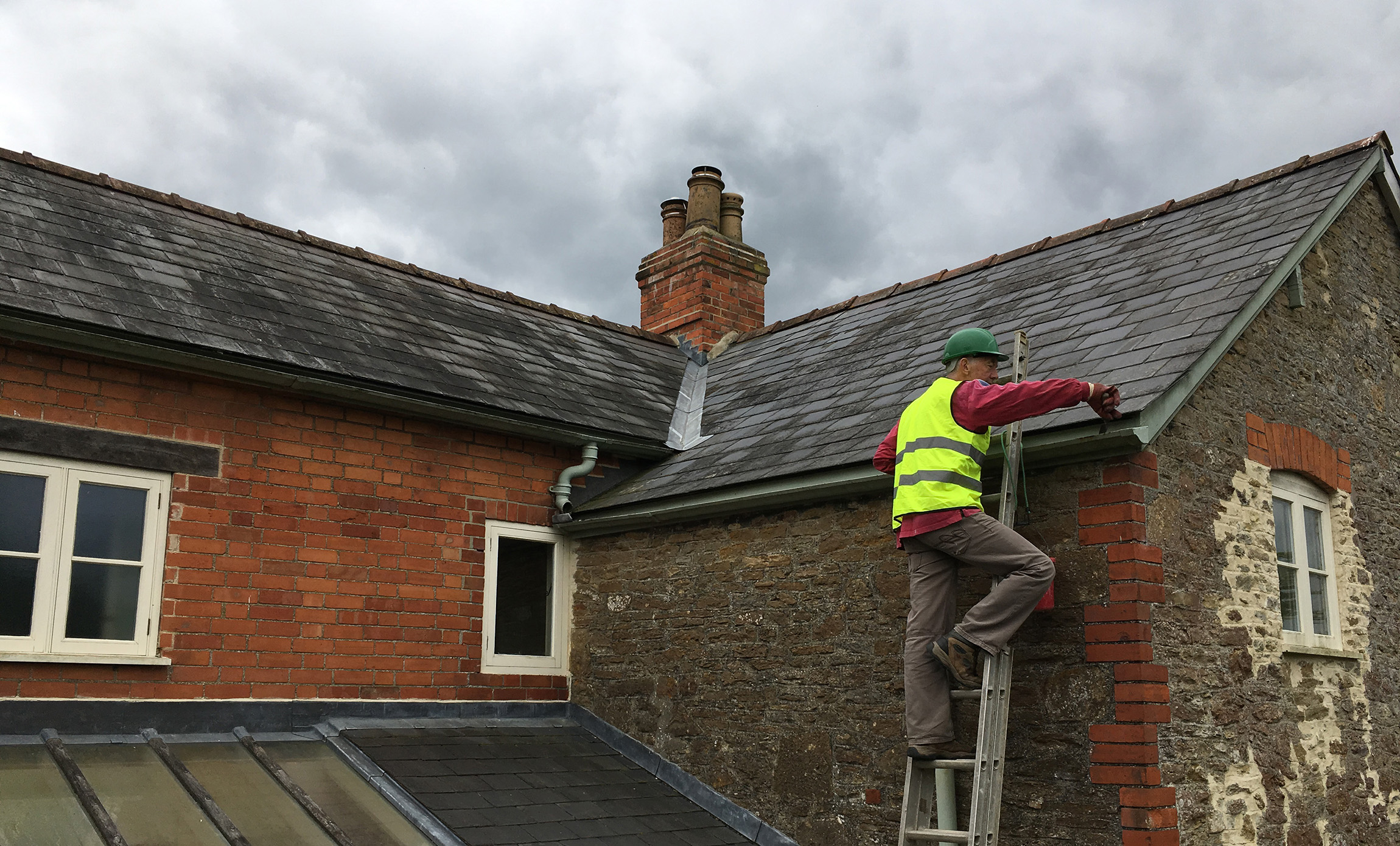 Cleaning out gutters on an old house in Dorset