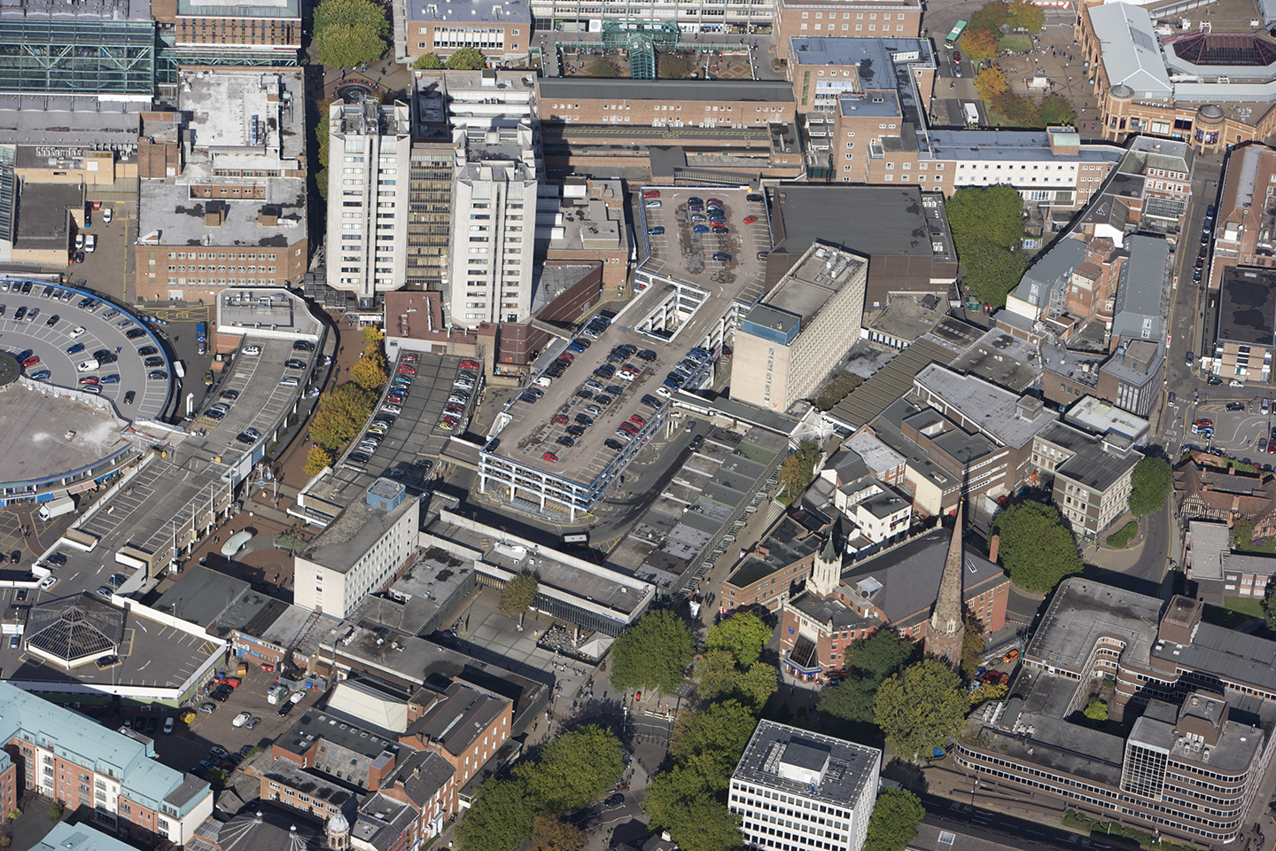A panoramic view of Coventry showing tower blocks, car parks and office buildings.