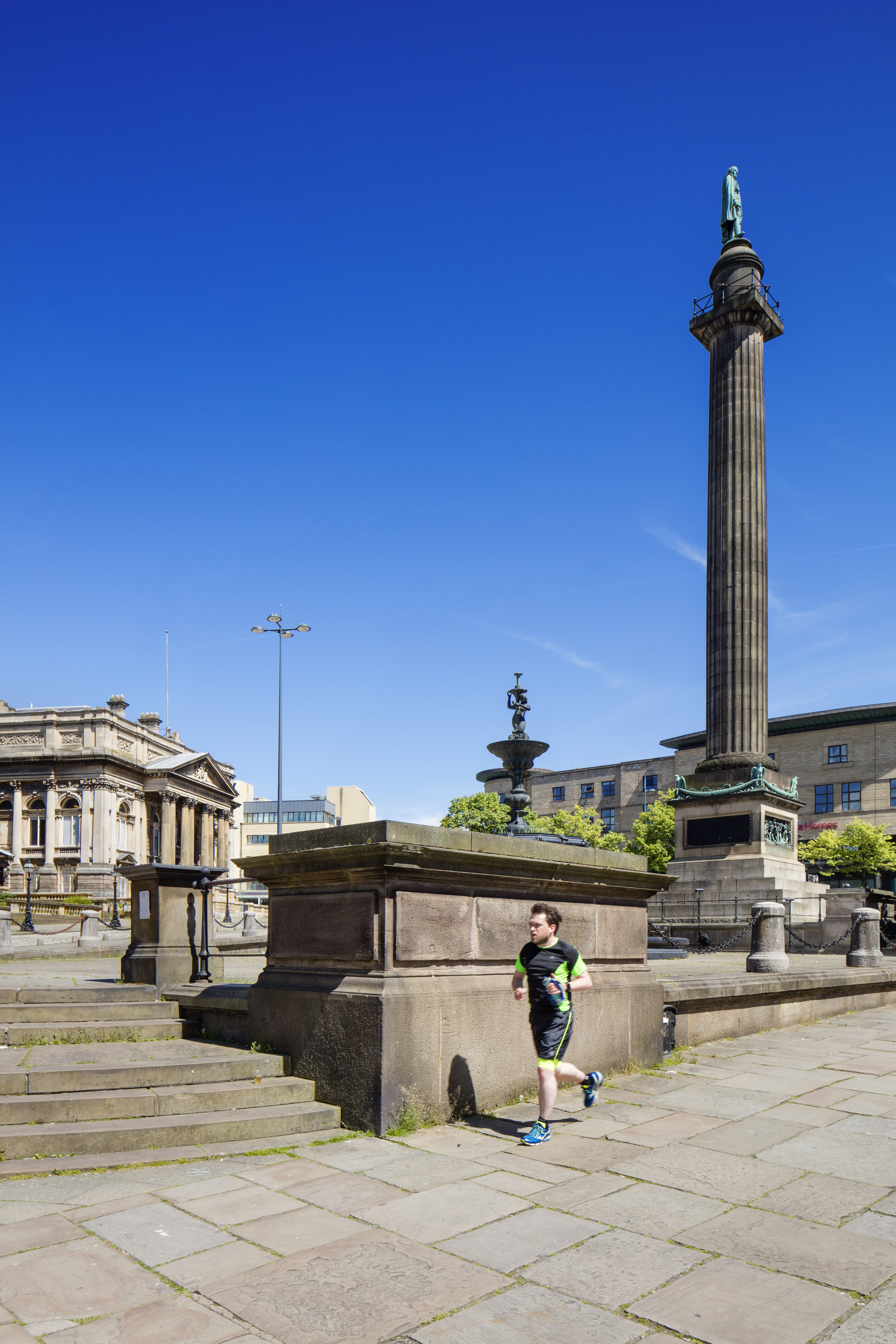 Photograph of the Wellington Column, Liverpool, with a jogger running past its base.