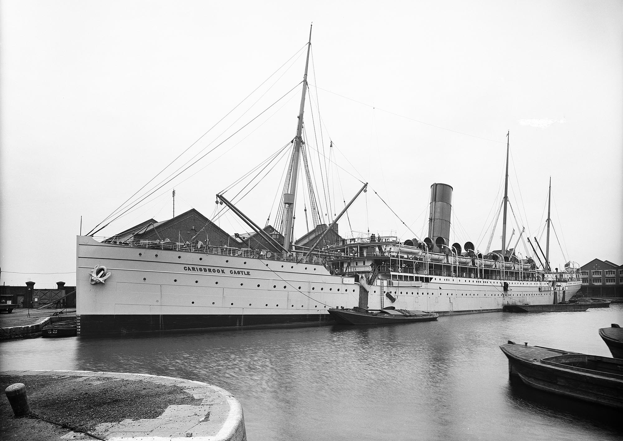 View of SS Carisbrook Castle in port with a tug alongside