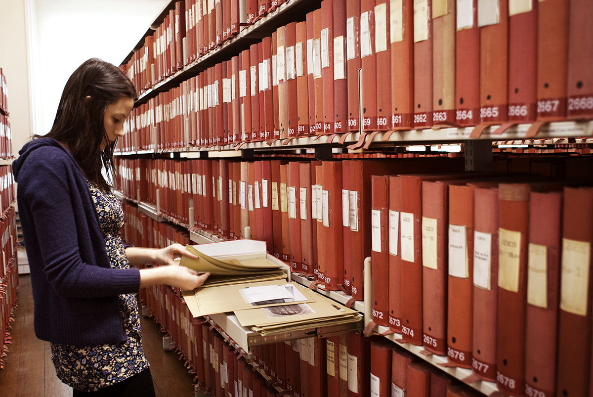 England's Places: A person looking at a box amongst the shelves