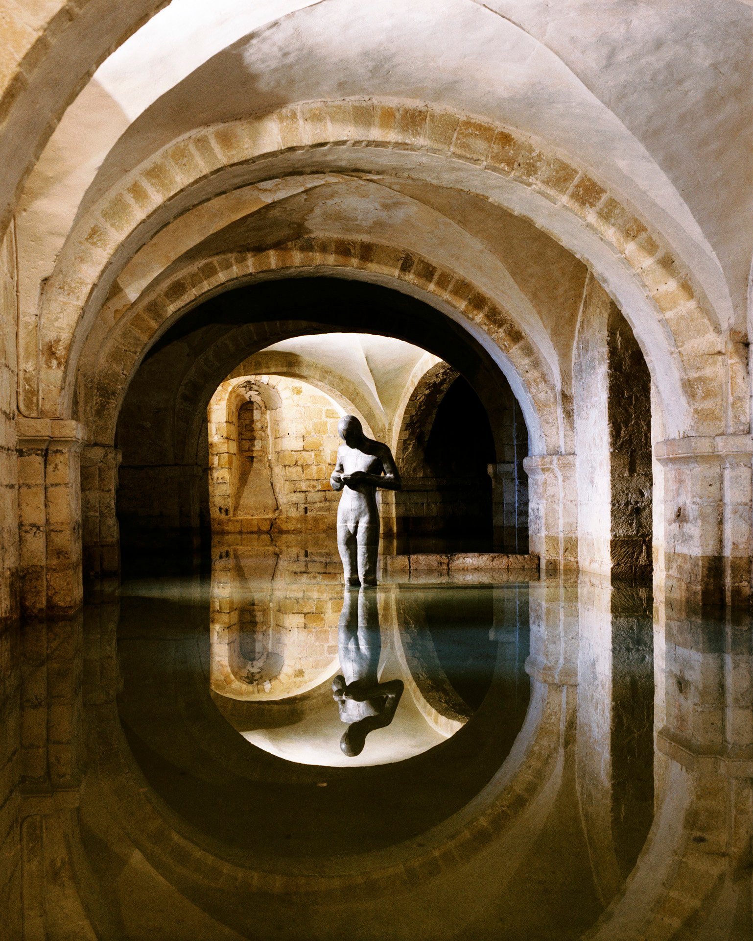 Antony Gormley statue in flooded crypt interior, Winchester Cathedral