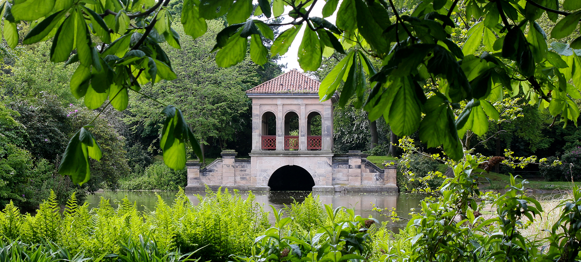 View across the lake to the Roman Boathouse in Birkenhead Park, The Wirral