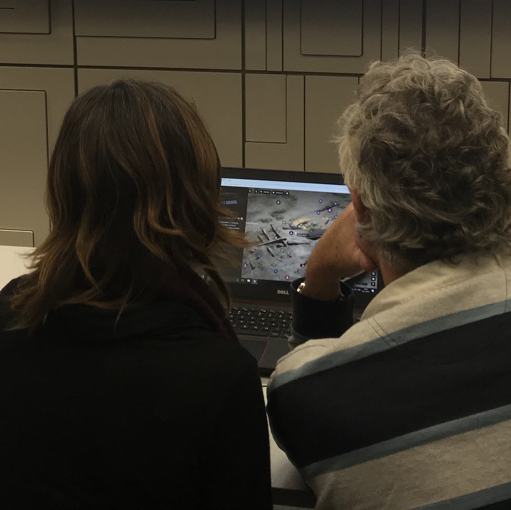 Man and woman watching a virtual wreck site tour on a laptop