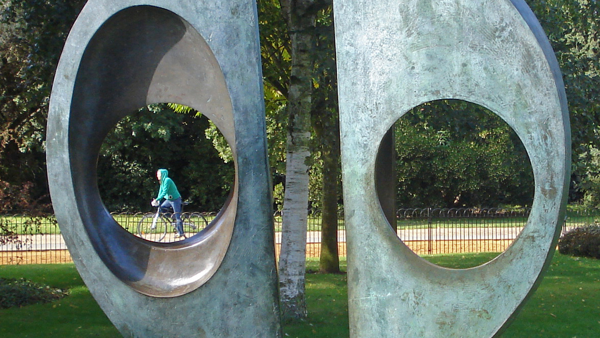 Two Forms (Divided Circle) with view of cyclist through on of the circles