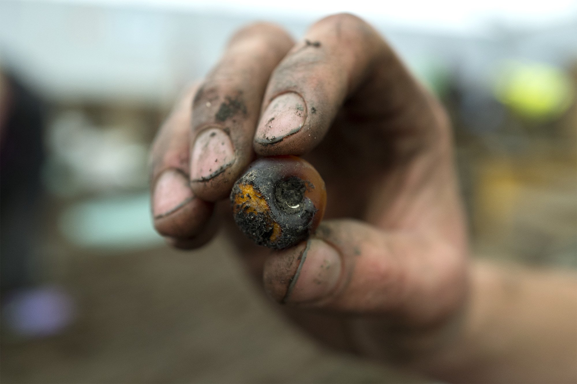 Image of an archaeologist holding an amber bead, found within the incredibly well preserved 3,000 year old roundhouses in the Fens