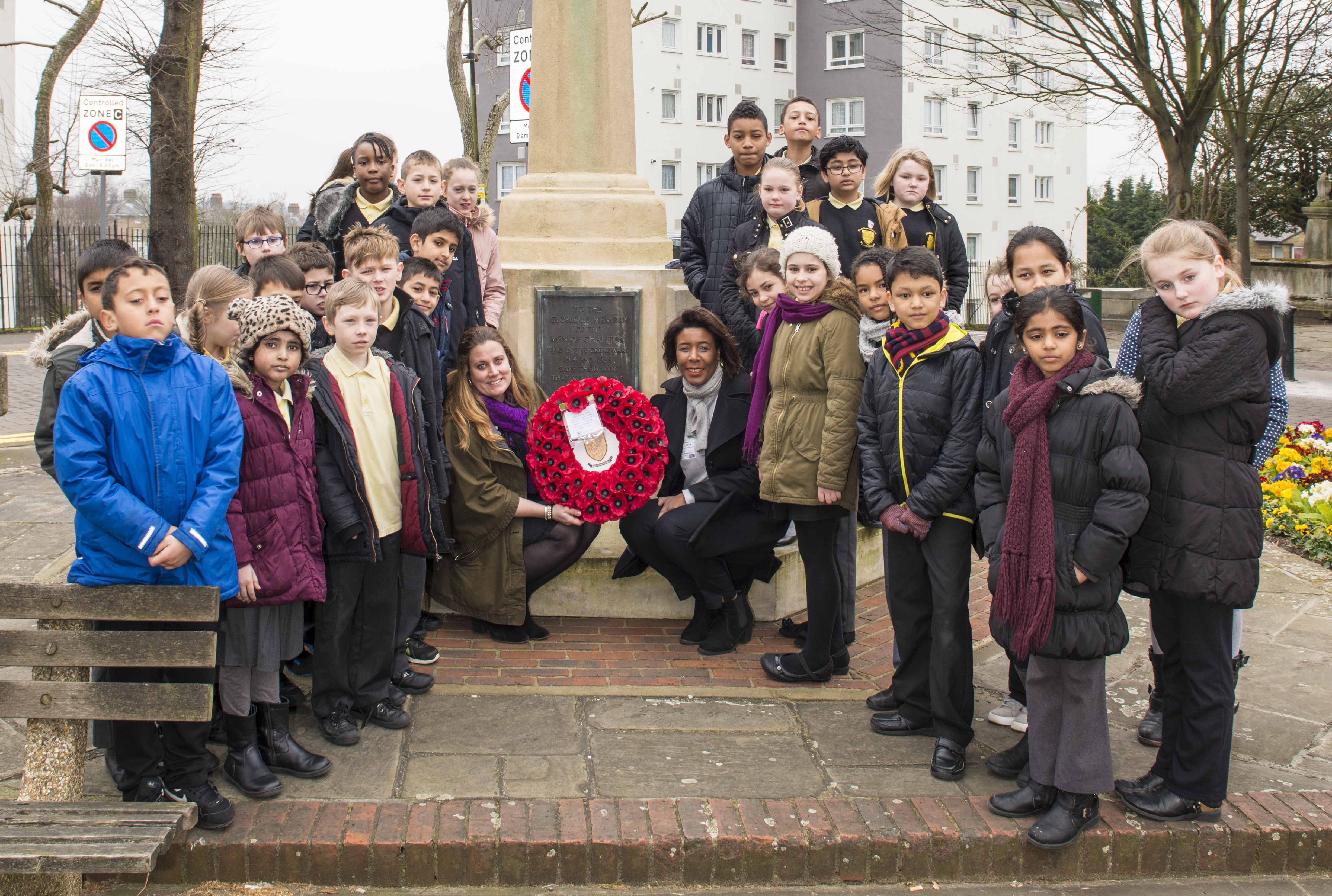 Children from Charlton Manor Primary School, Tiva Montalbano First World War Programme Manager at Historic England and Cllr Denise Scott-Mcdonald gather at the war memorial to lay a wreath.