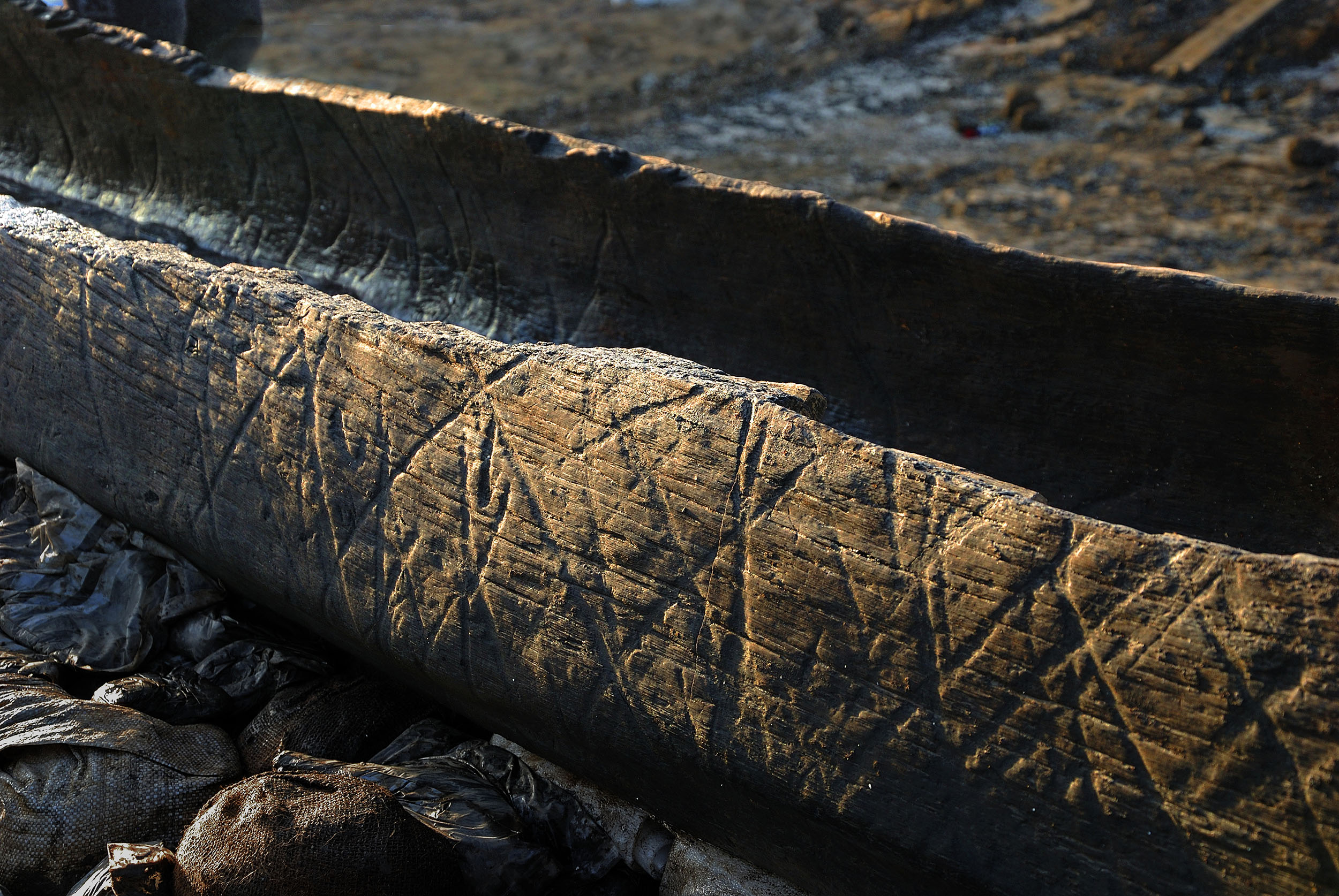 Detail of Boat 1, showing diagonal grooved markings on the interior and exterior of the 6.3m oak logboat which was excavated in 2011–12. This boat, which dates to the Early Iron Age, was found in the Must Farm palaeochannel c. 250m upstream of the location of the current timber platform investigation.