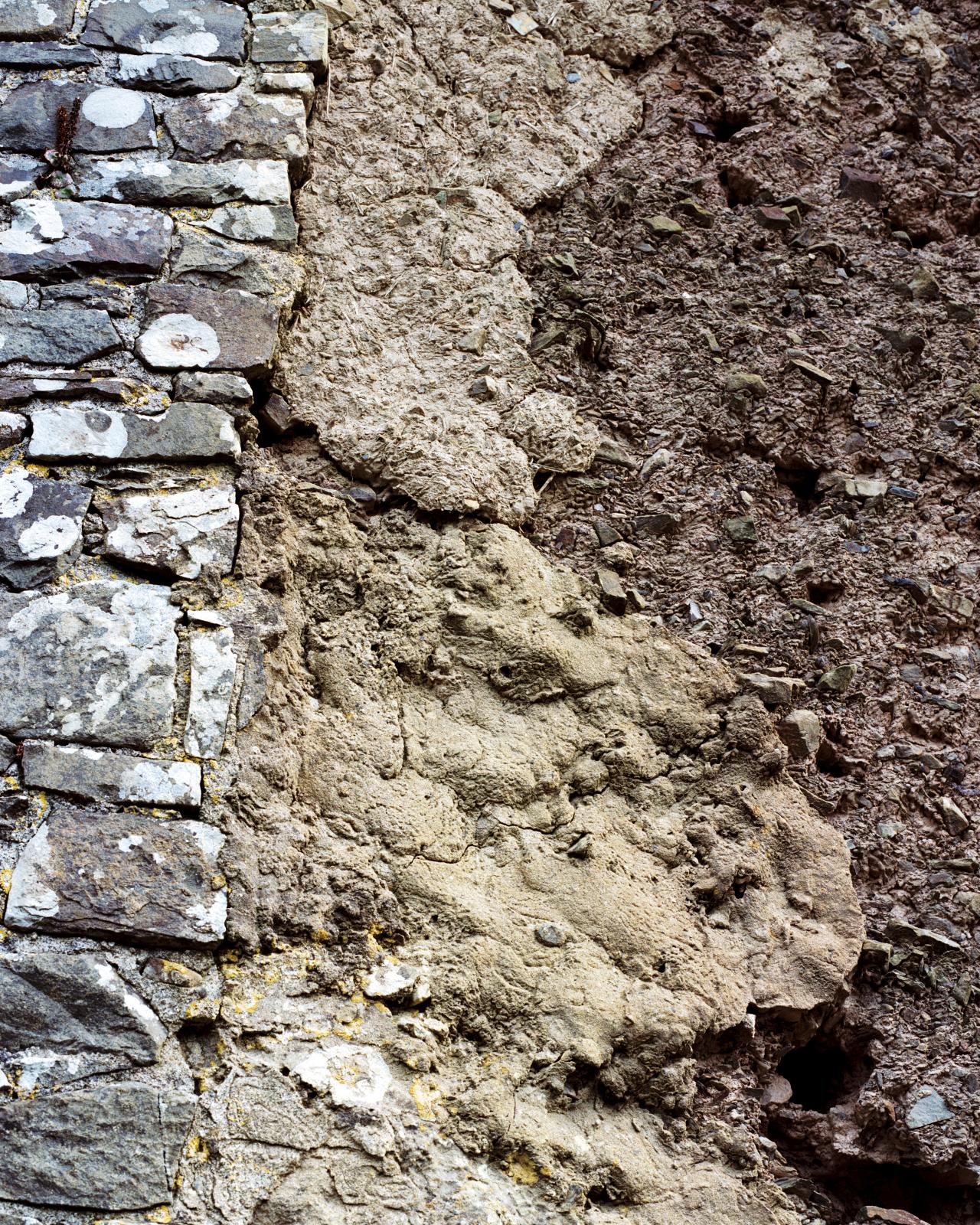 exterior detail of the stone and cob wall of a barn