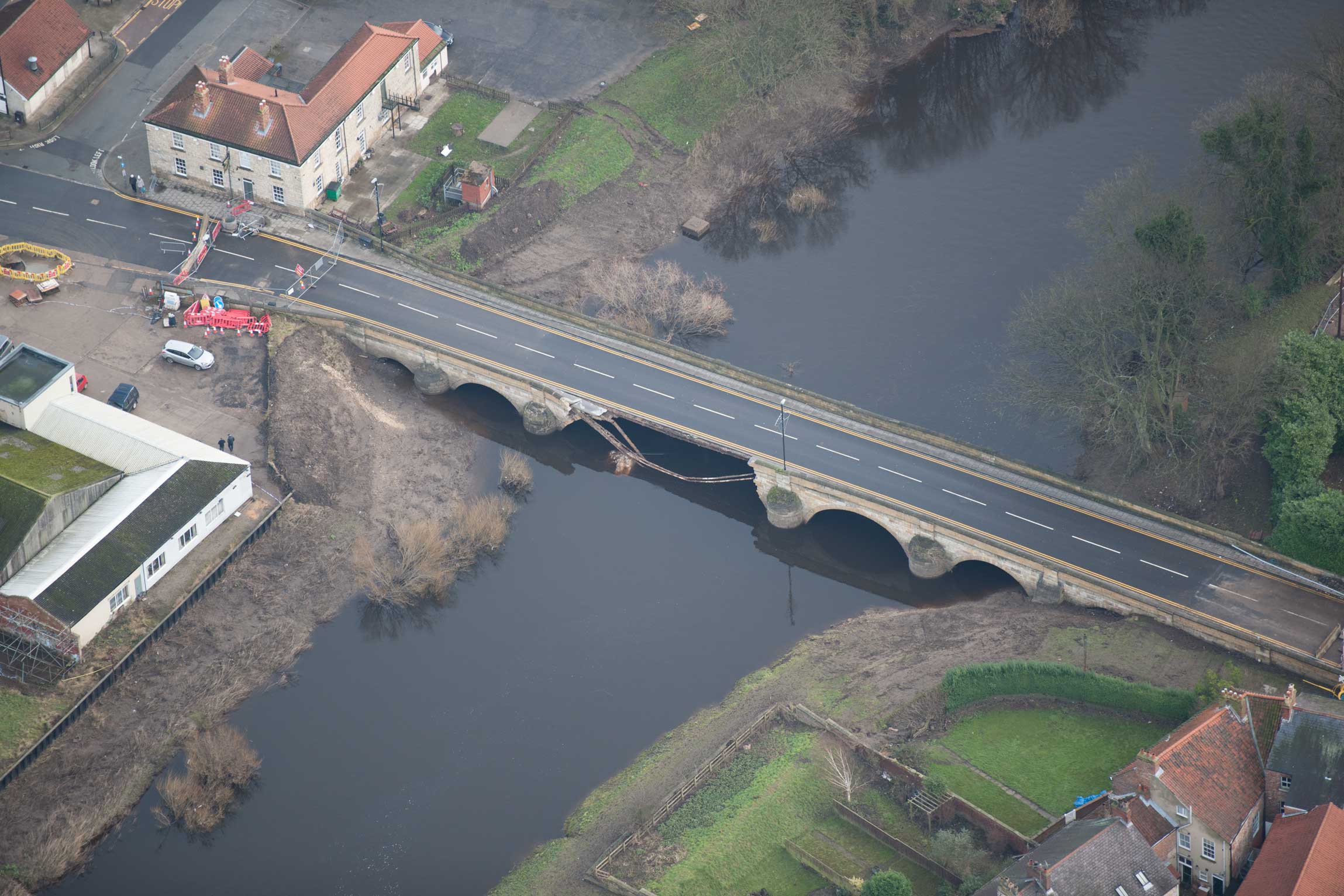 Aerial photograph of a damaged historic bridge.