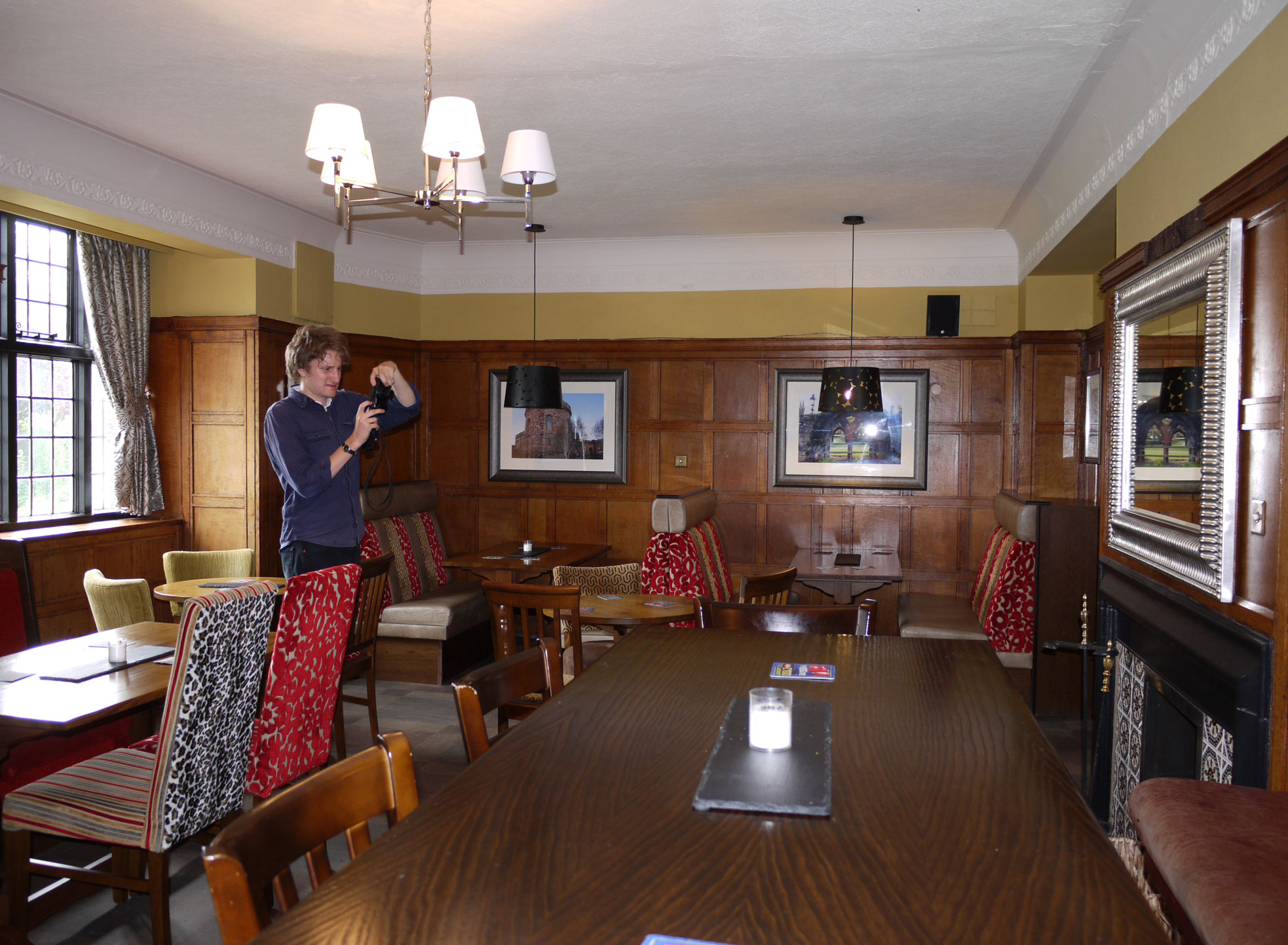 A Historic England Investigator taking photographs of the interior of a historic public house, the Redfern Inn