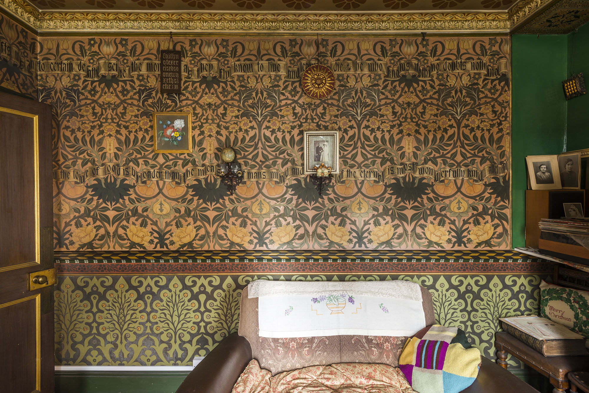 The intricate green and gold design of a wall in the drawing room at artisan decorator David Parr's House in Cambridge
