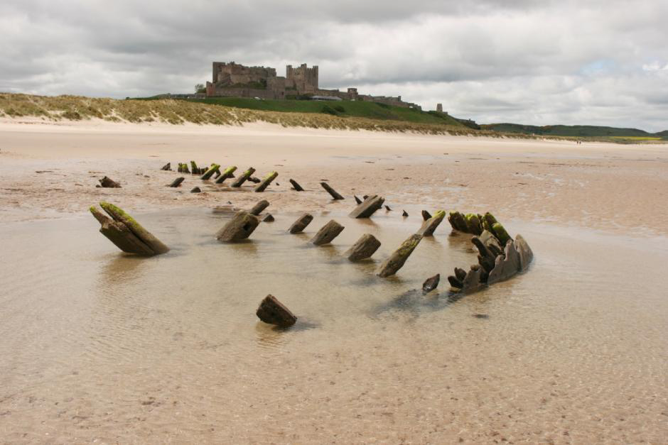 The wreck of a late 18th-century coastal sailing vessel on the beach below Bamburgh Castle, Northumberland, scheduled monument