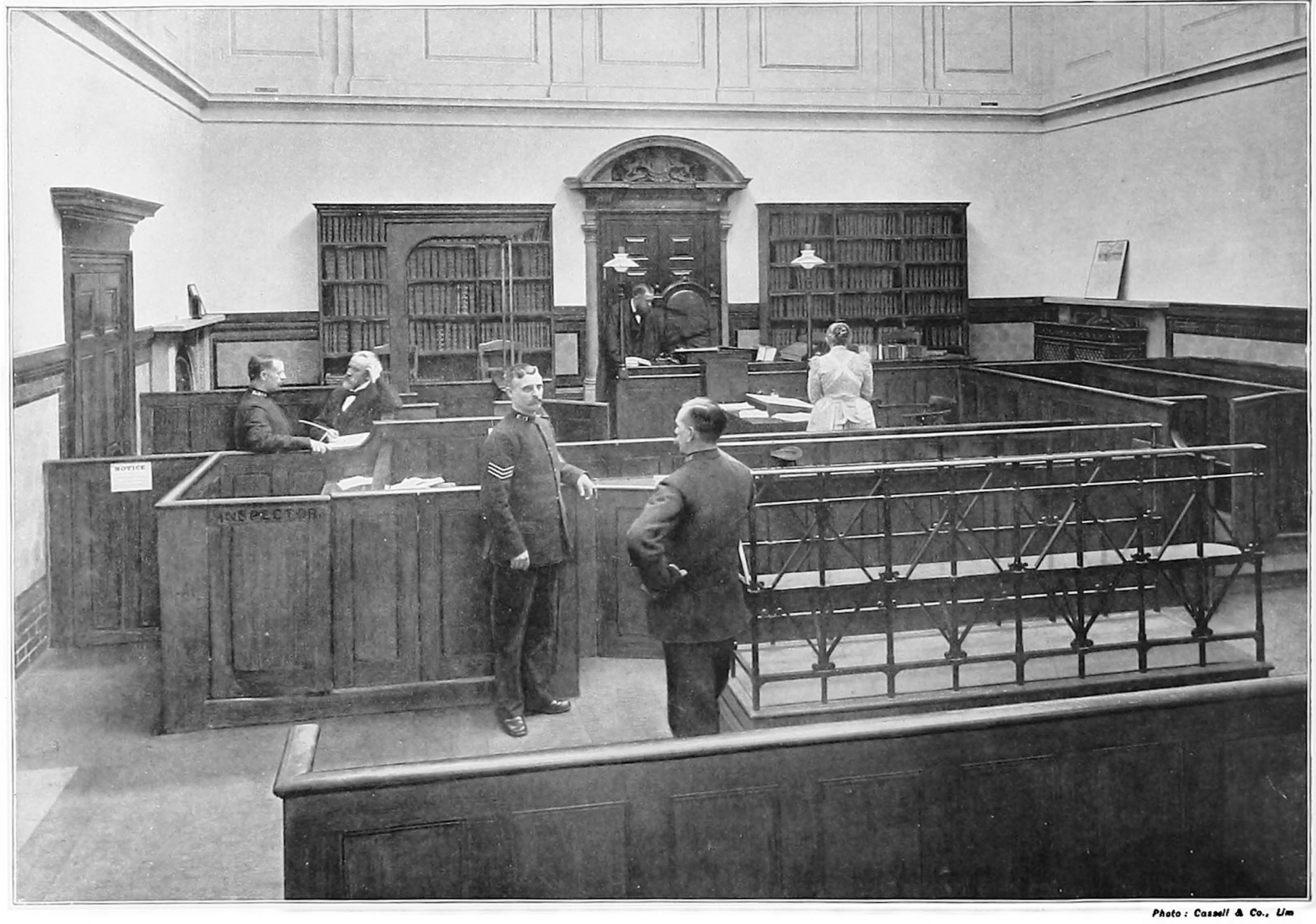 Court room, almost empty but for six people including three policeman going about their work or talking.