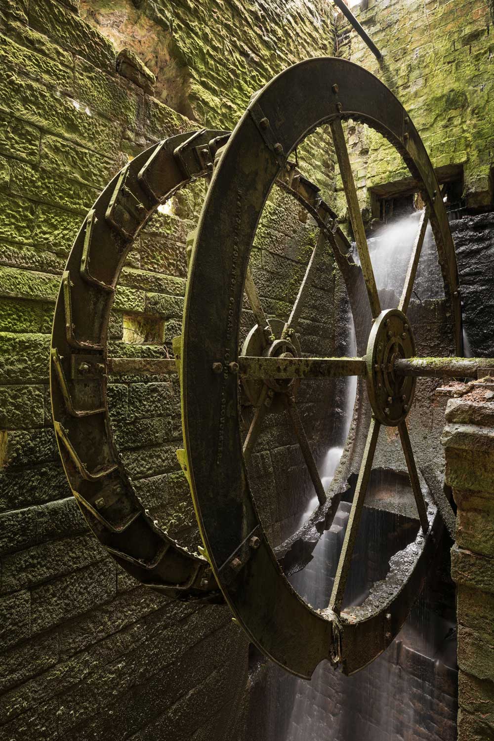 A photograph of a historic cast iron water wheel