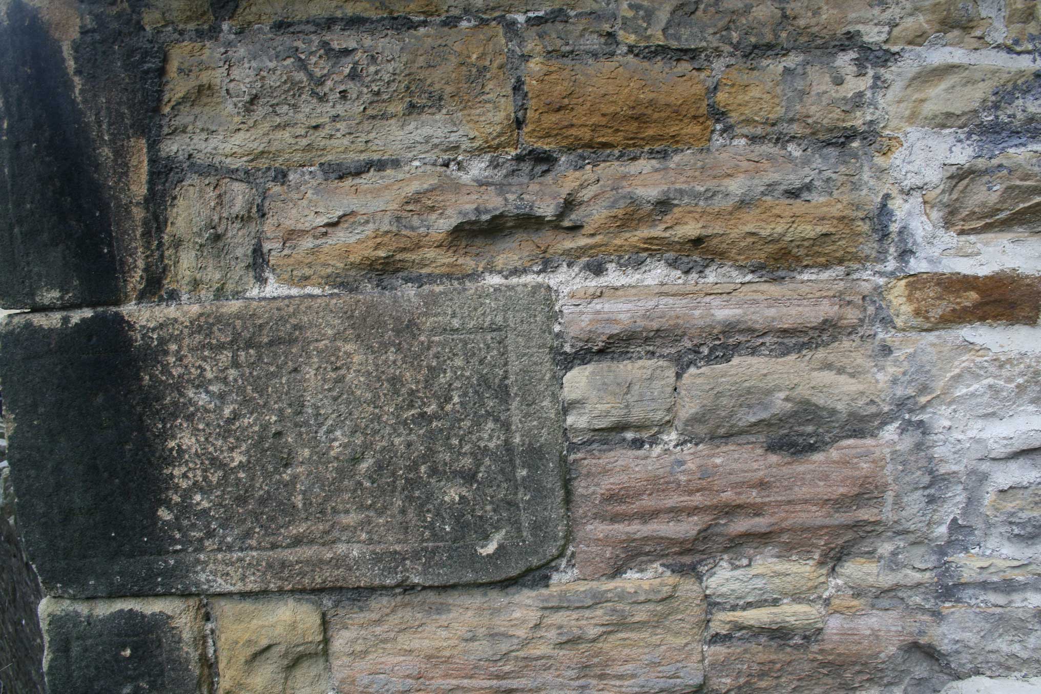A detail of stonework in the exterior of a historic building.