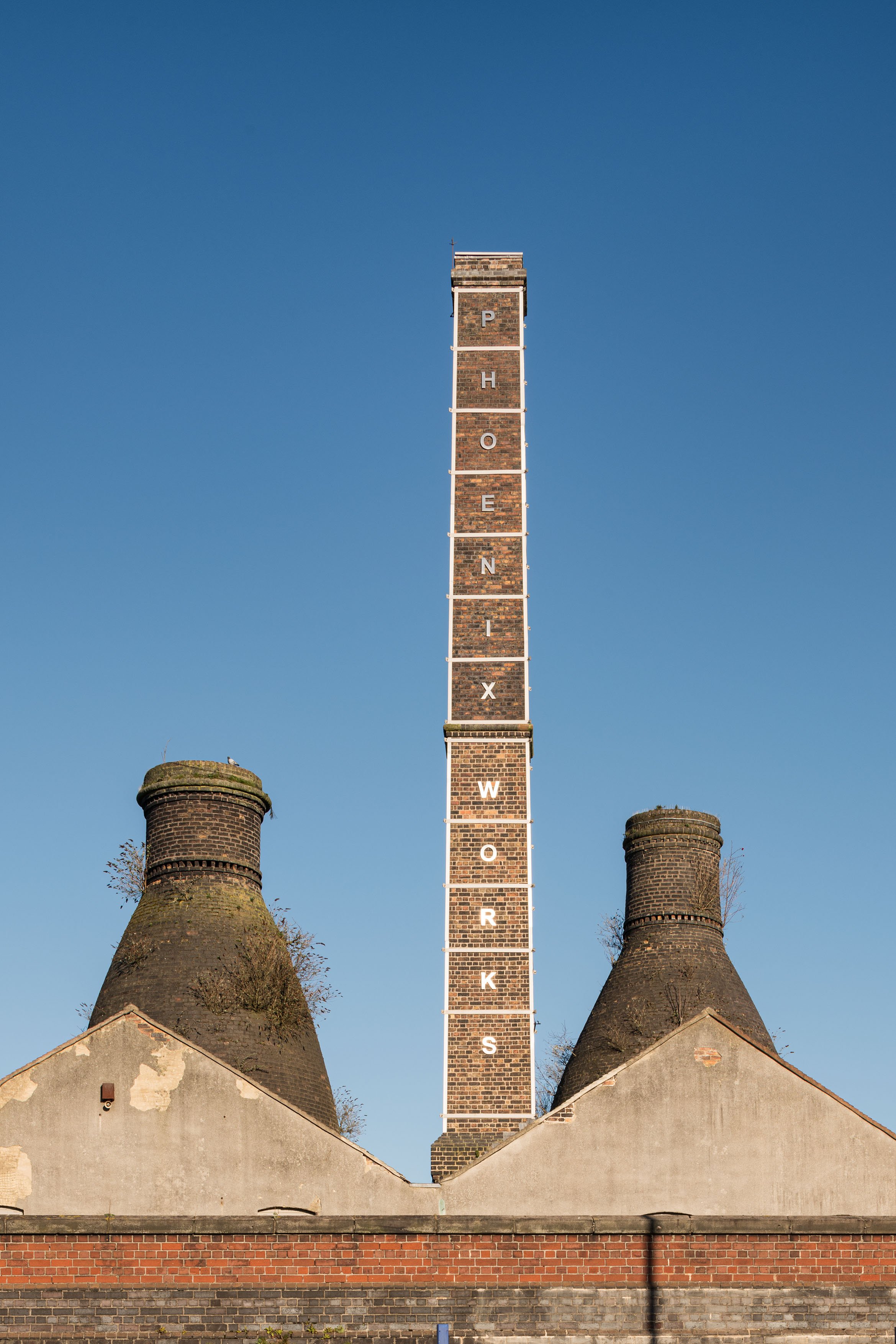 A tall brick chimney with a blue sky