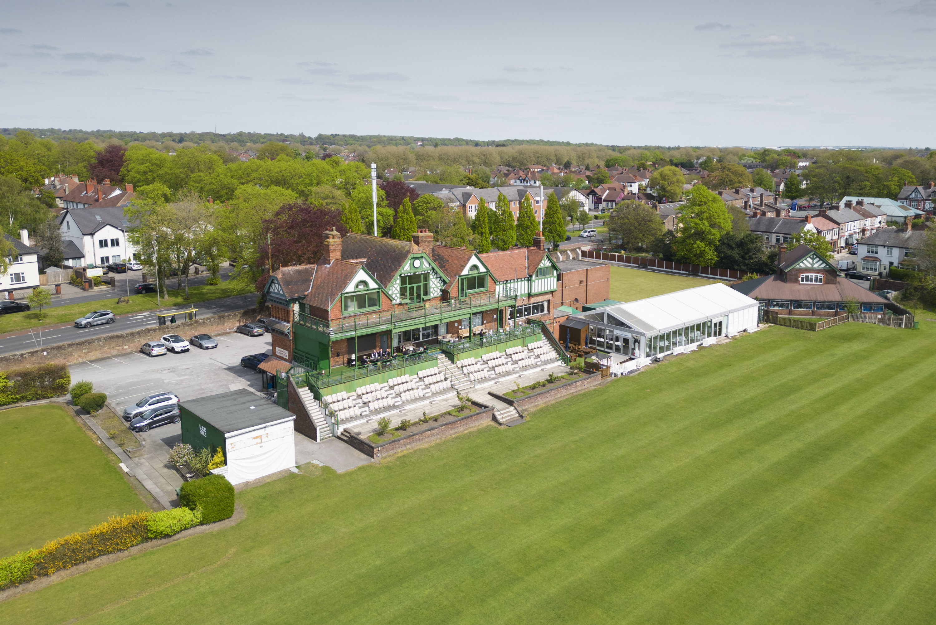 A cricket pavilion and the edge of the cricket pitch as viewed from above