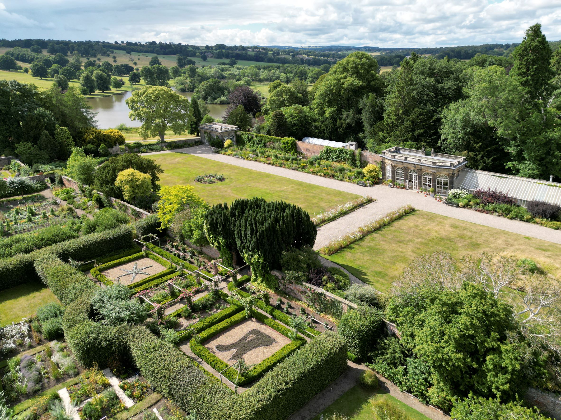 The grounds of Ripley Castle seen from the air. The formal gardens are seen in the foreground with wider parkland and a pond in the background.