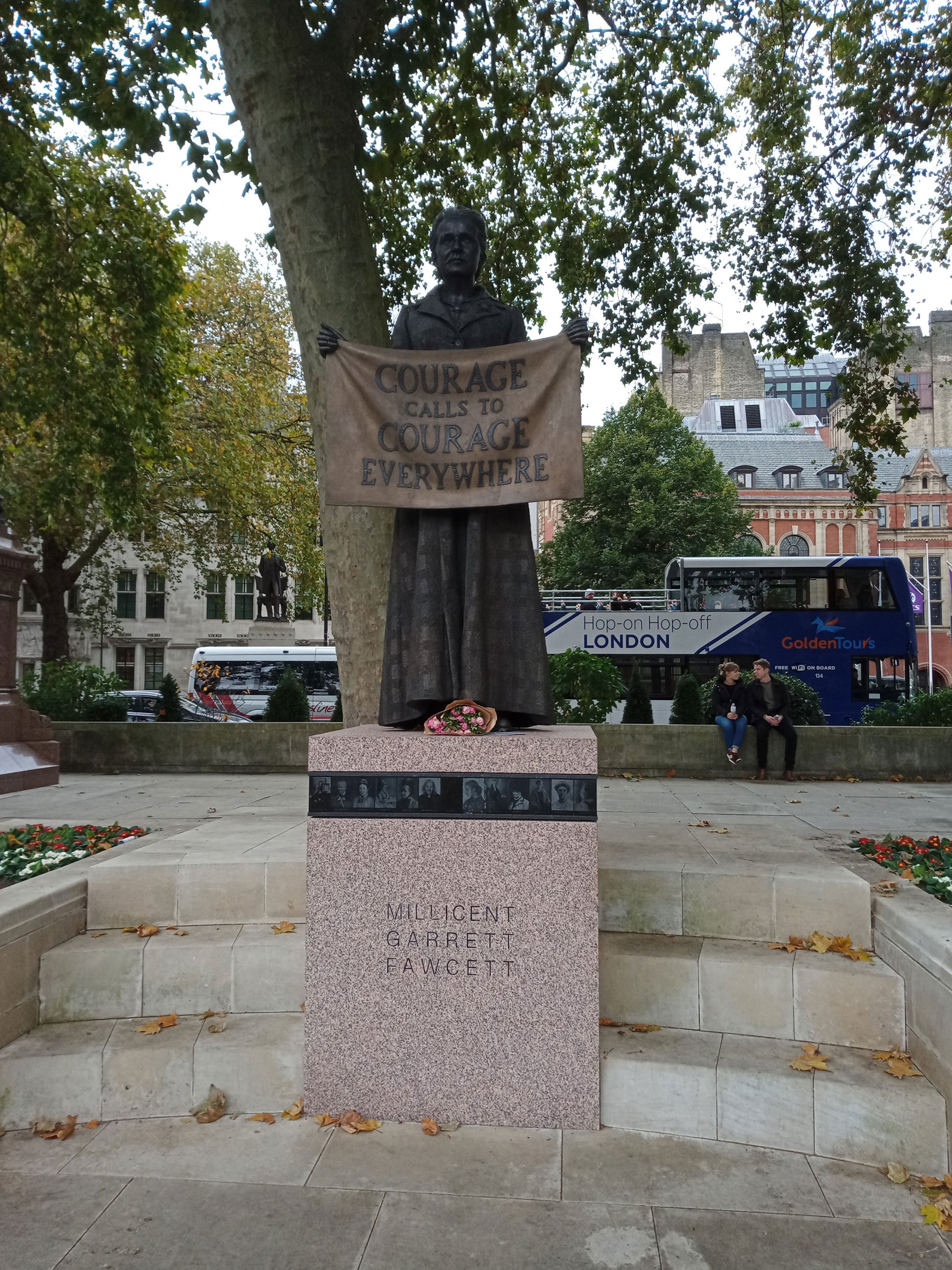 A bronze statue of a woman holding a banner in front of her which reads 'courage calls to courage everywhere'. On the plinth are small portraits of other women.