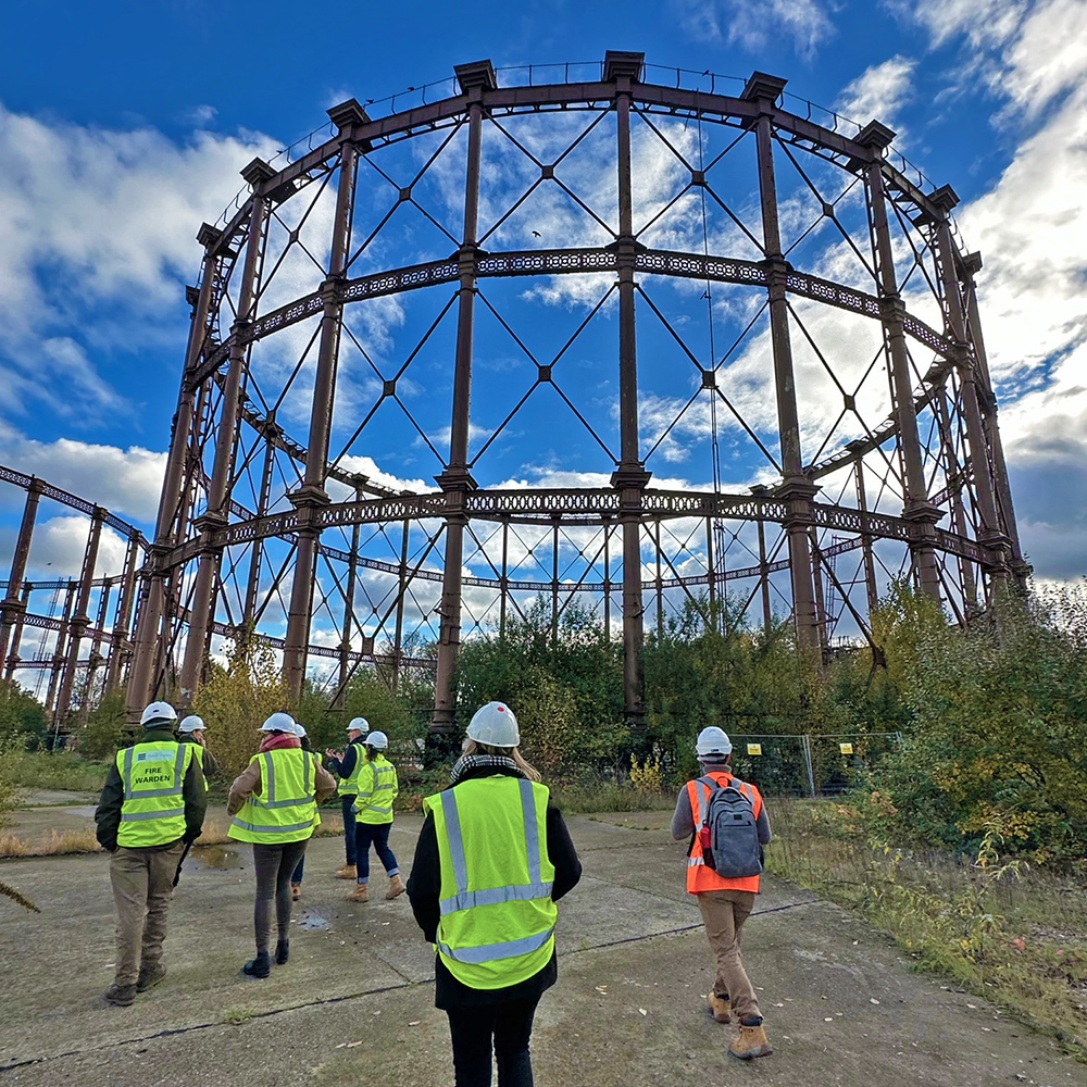 A group of people in hi-vis jackets and helmets on a site visit. 