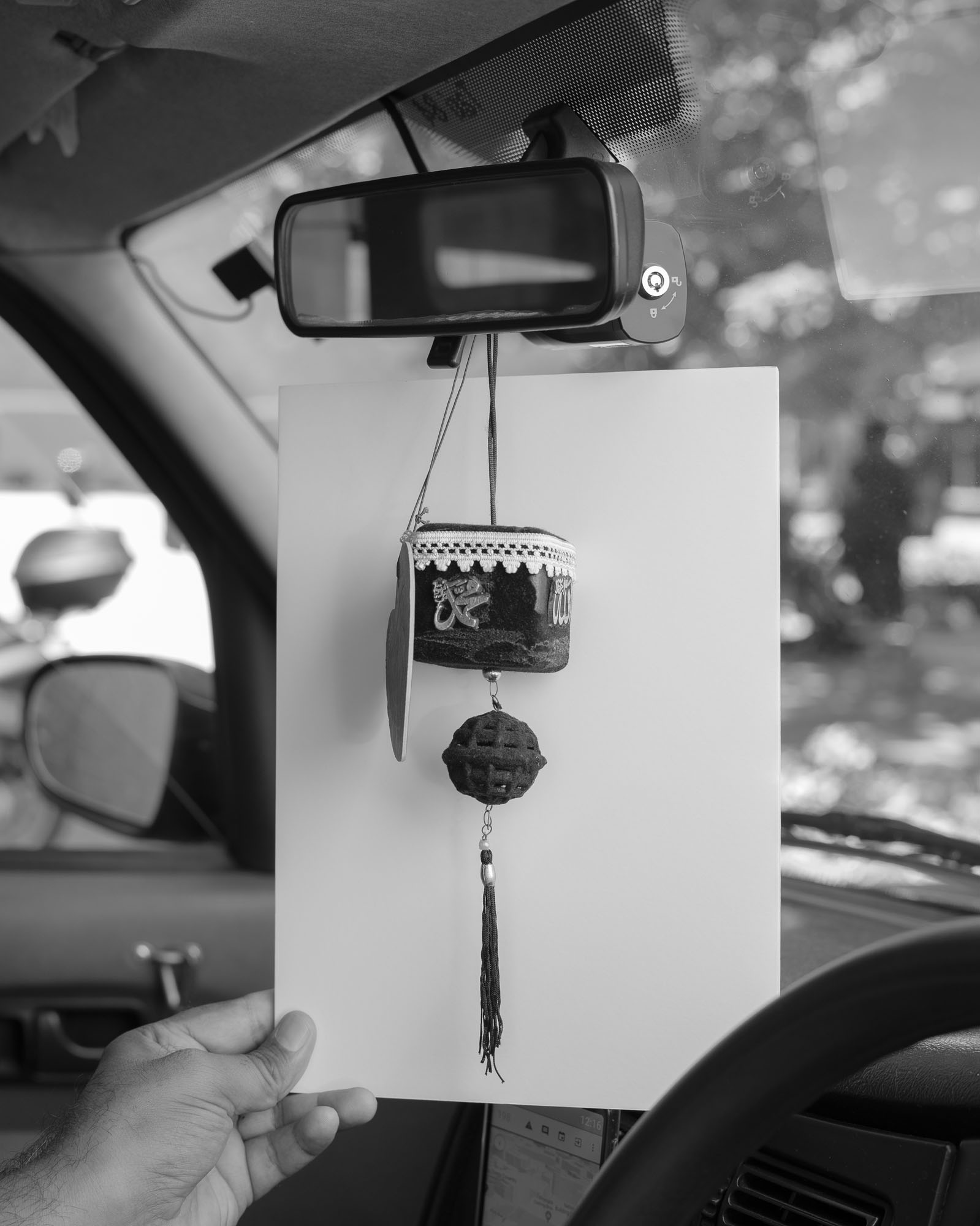 An item representing a Kaaba hanging from the rearview mirror of a car.