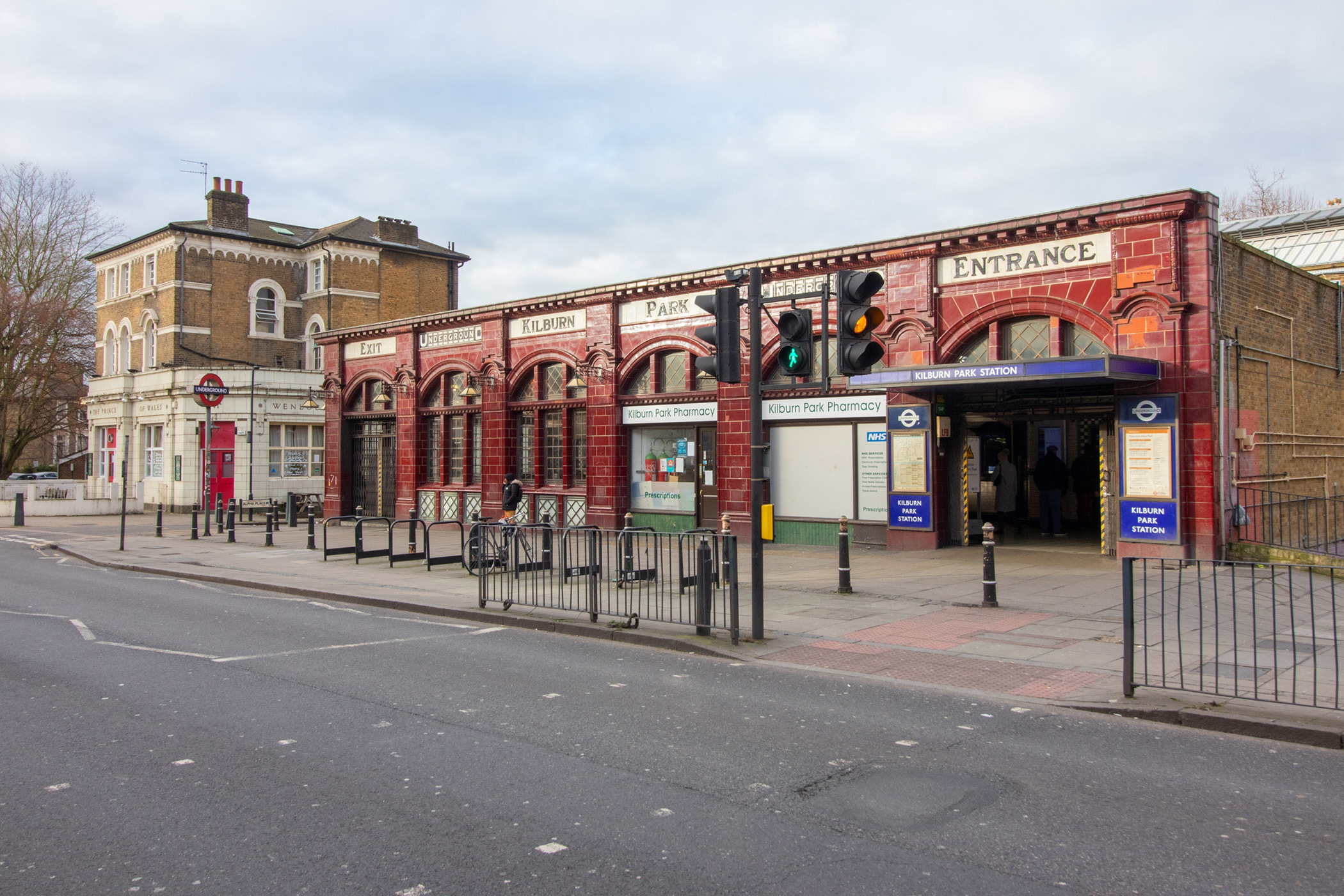 Red tiled tube station. Signs along the top of the building read (left to right):
Exit; Underground; Kilburn; Park; Underground; Entrance.