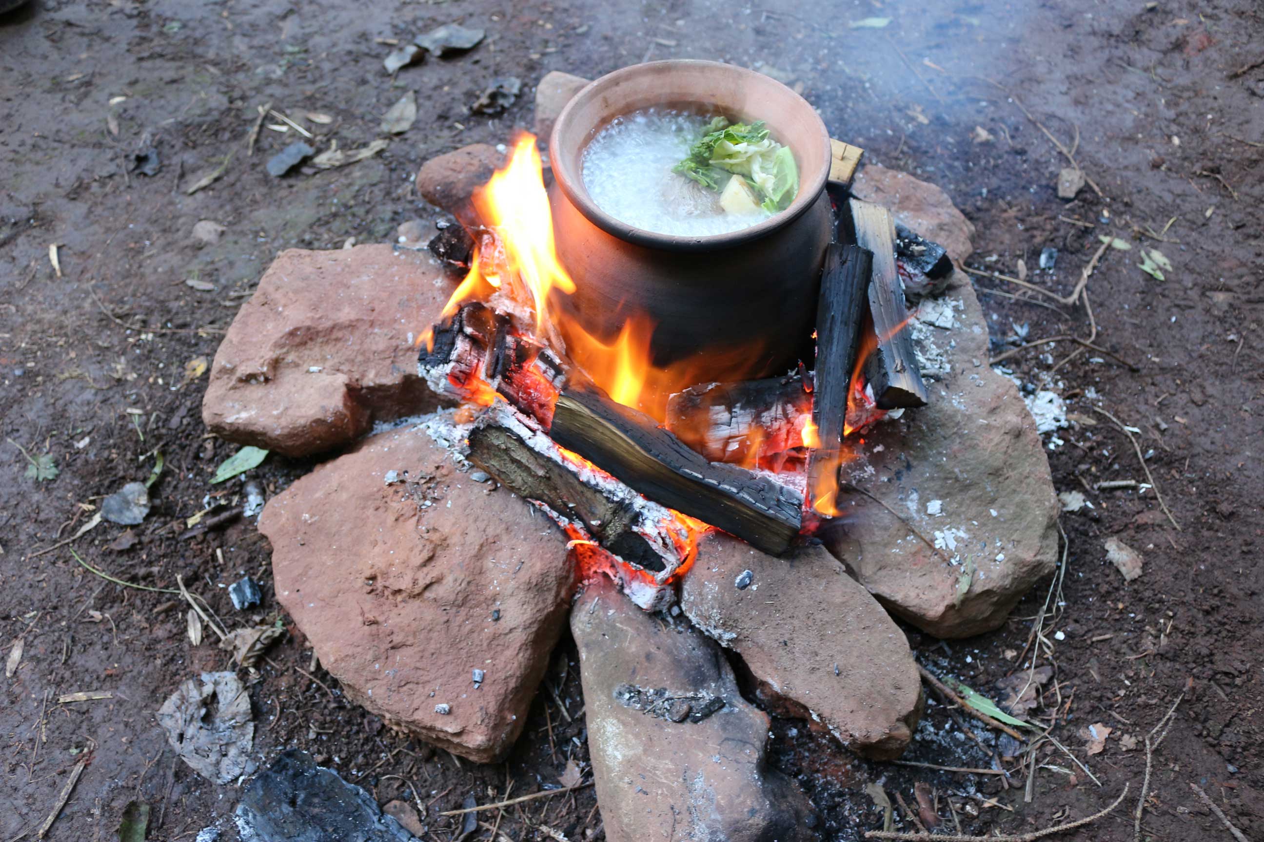 A reconstructed cooking pot and contents over a fire