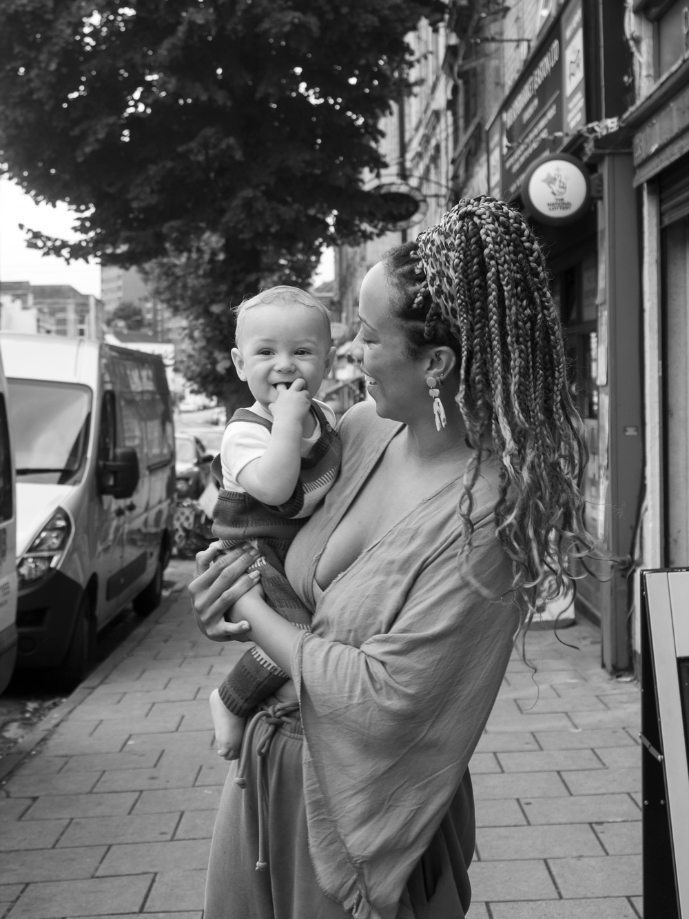 Black and white photo of a young mother holding her child, on Stapleton Road. 