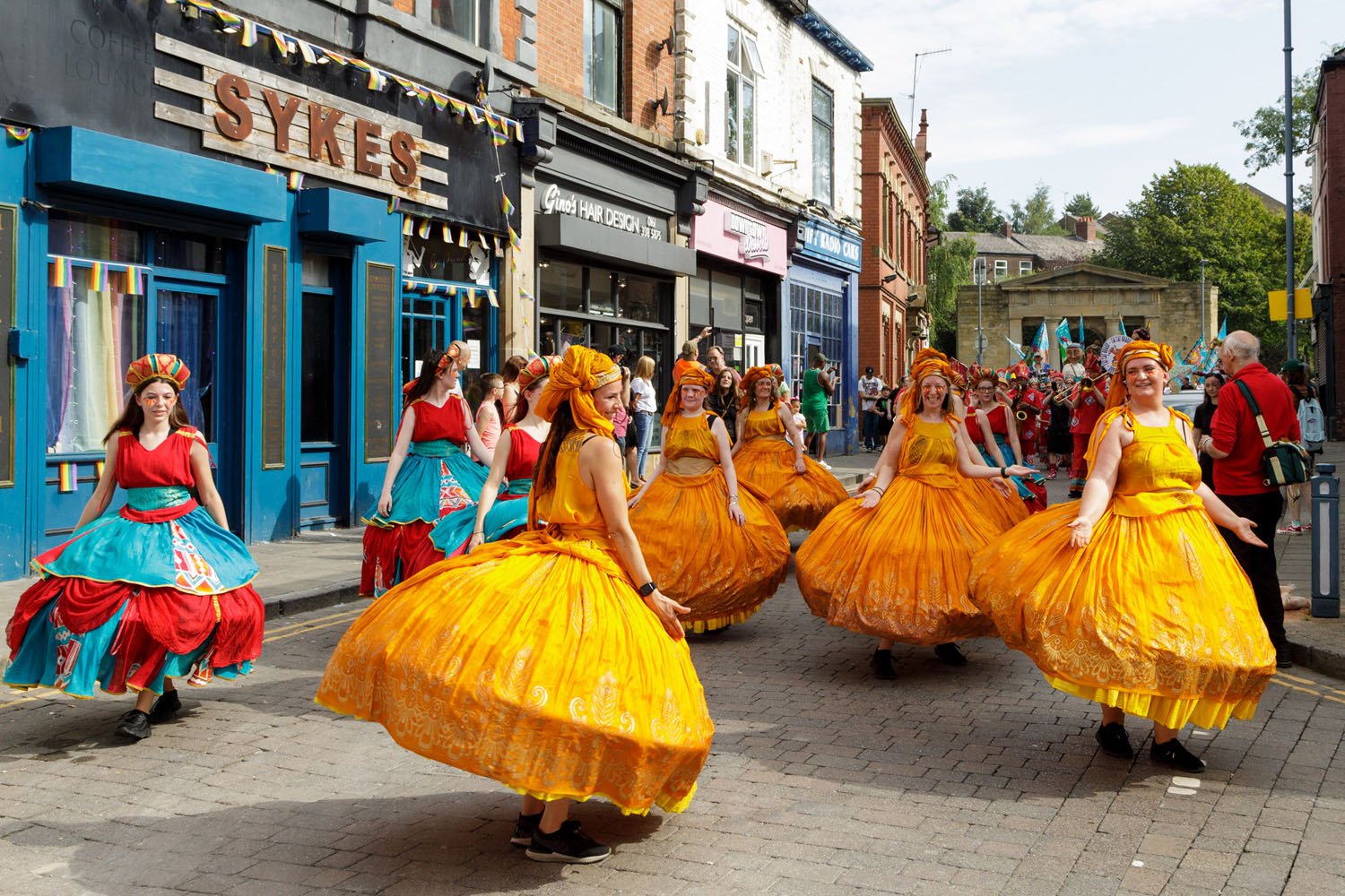 A colourful street procession of women dancing.