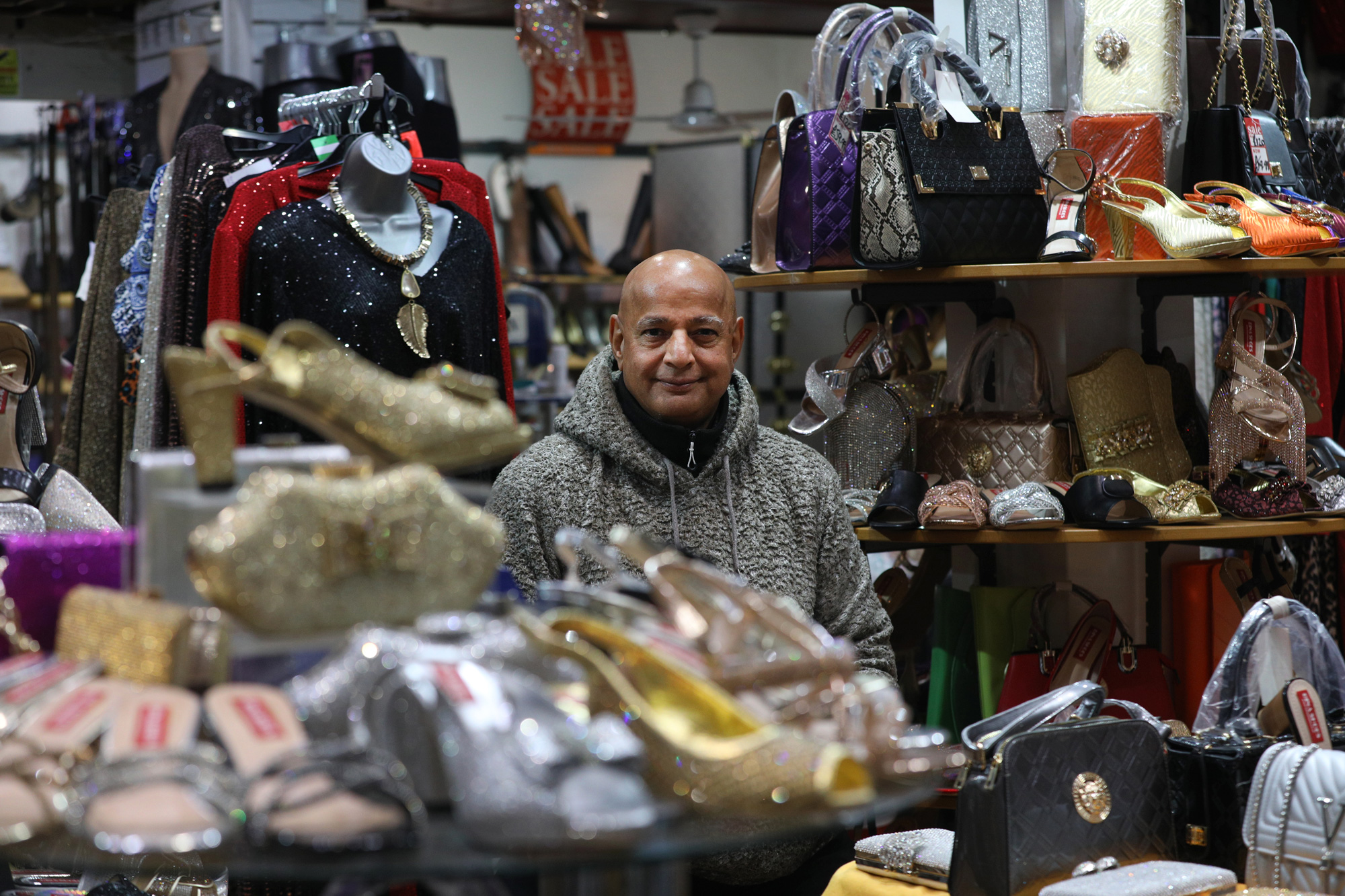 Portrait of a man in a women's fashion shop, surrounded by displays of shoes, clothing and accessories.