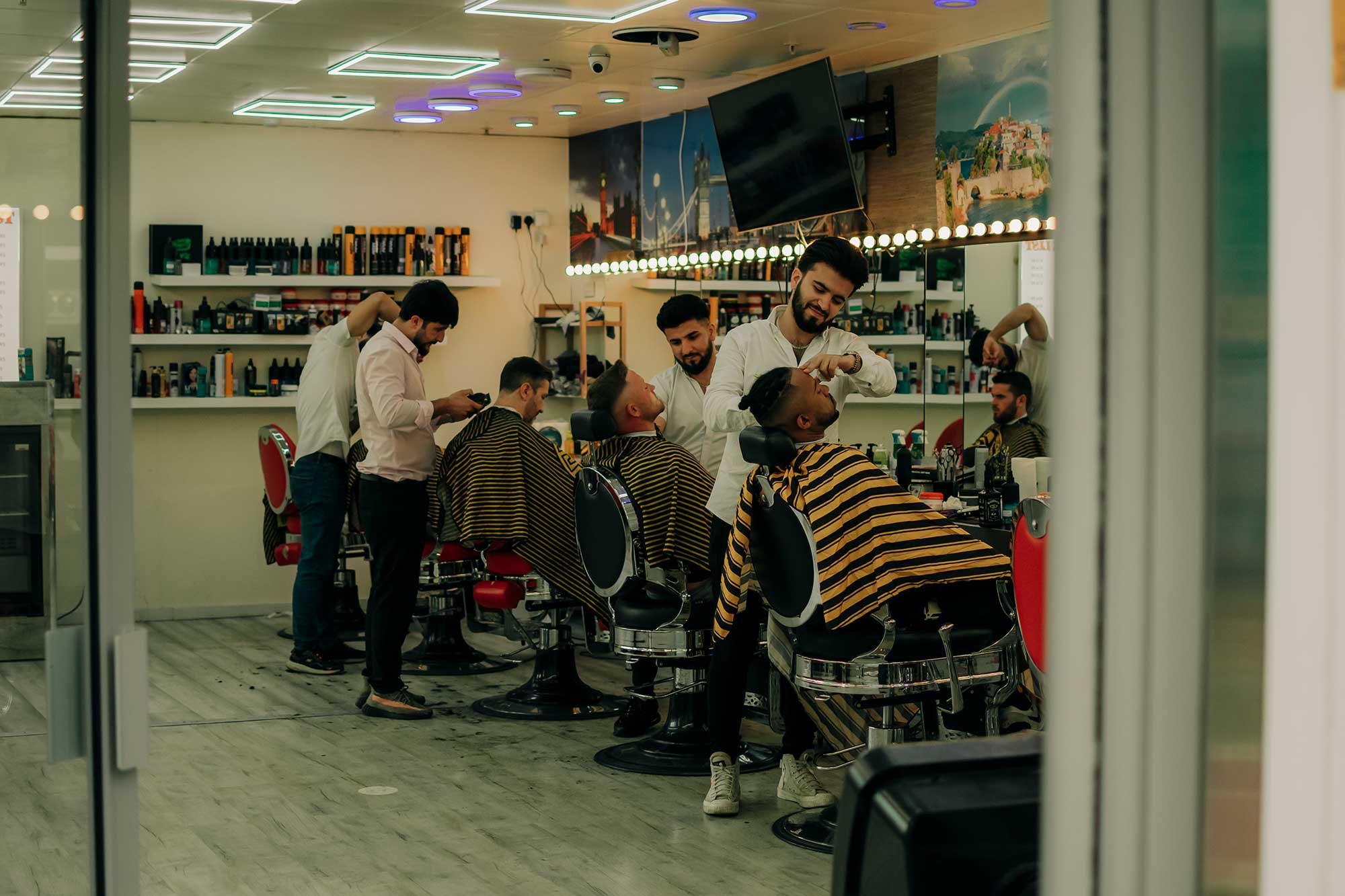 Men having shaves and their hair cut in a barbershop.