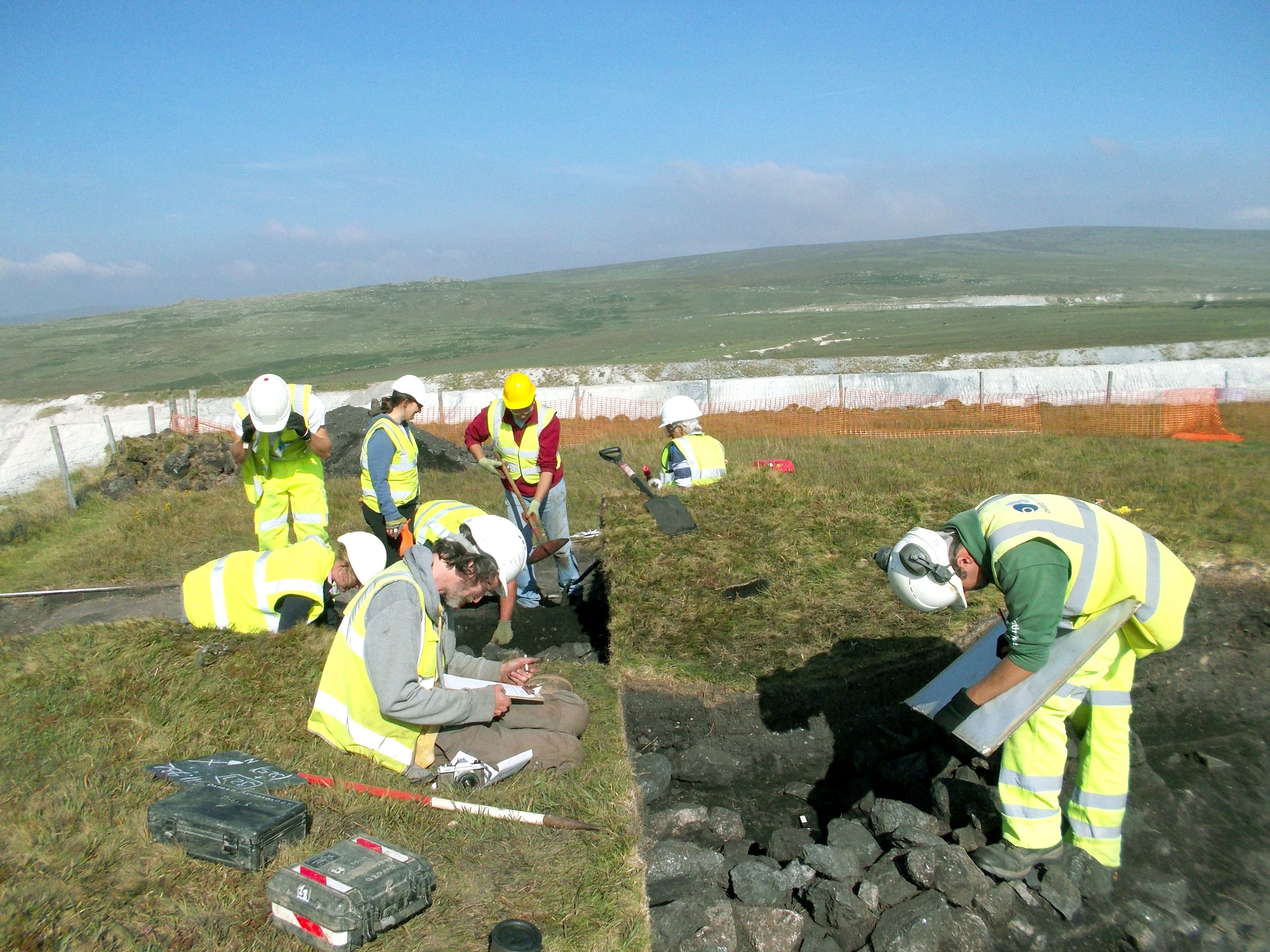 Archaeologists excavating and recording a barrow.