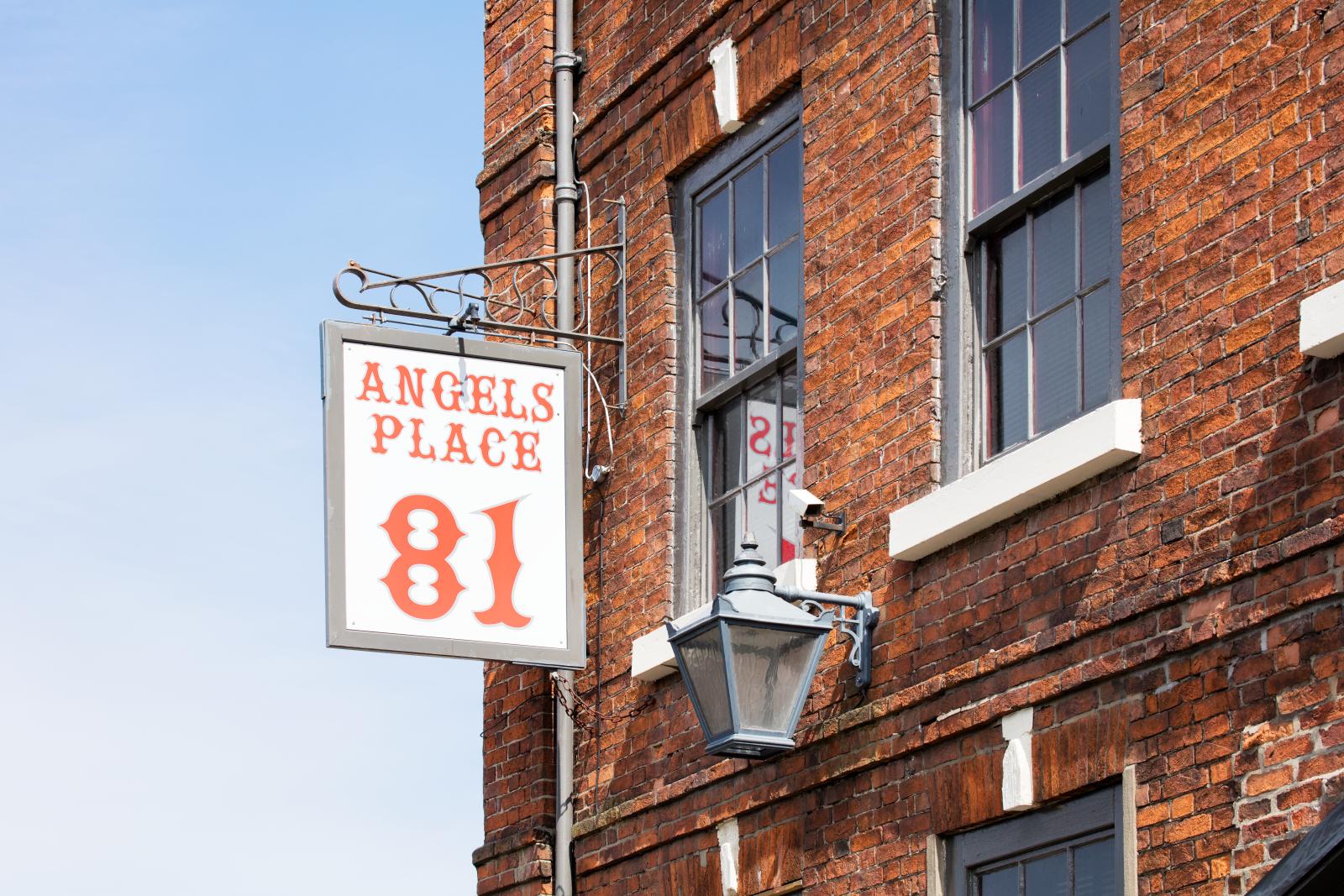Signage on the side of a building which reads 'Angels Place 81'.