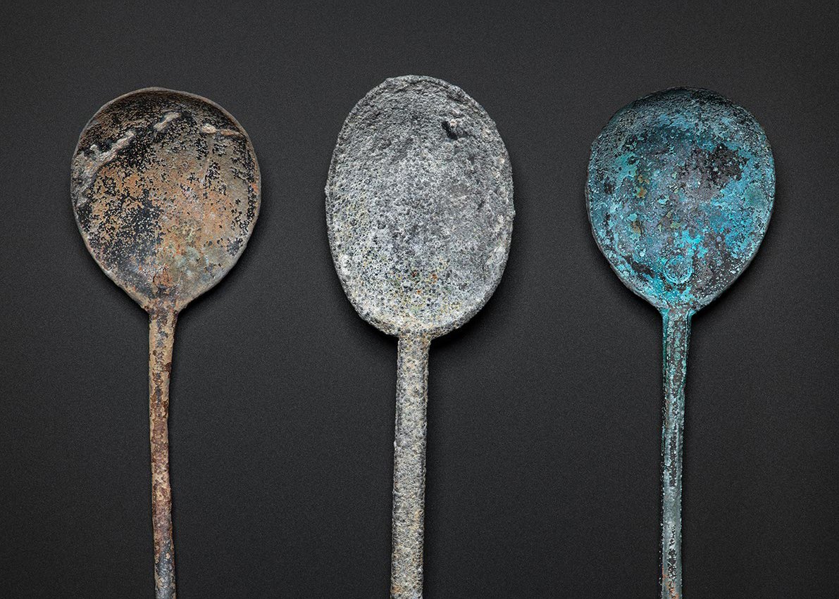 A selection of spoons. Left: copper alloy spoon with round maker’s mark at the base. Centre: pewter spoon. Right: copper alloy spoon with round maker’s mark at the base.