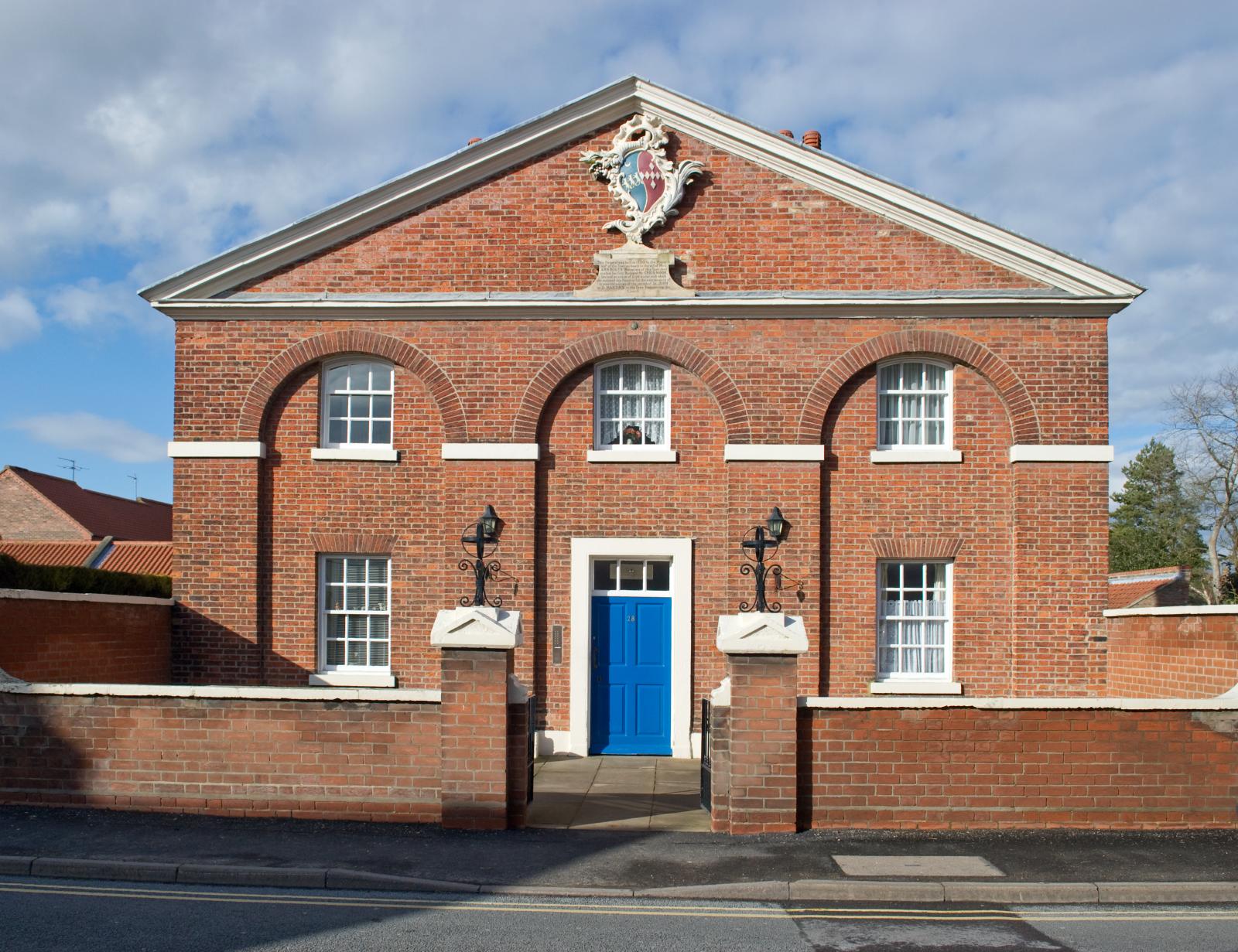 Red brick building with a coats of arms at the top