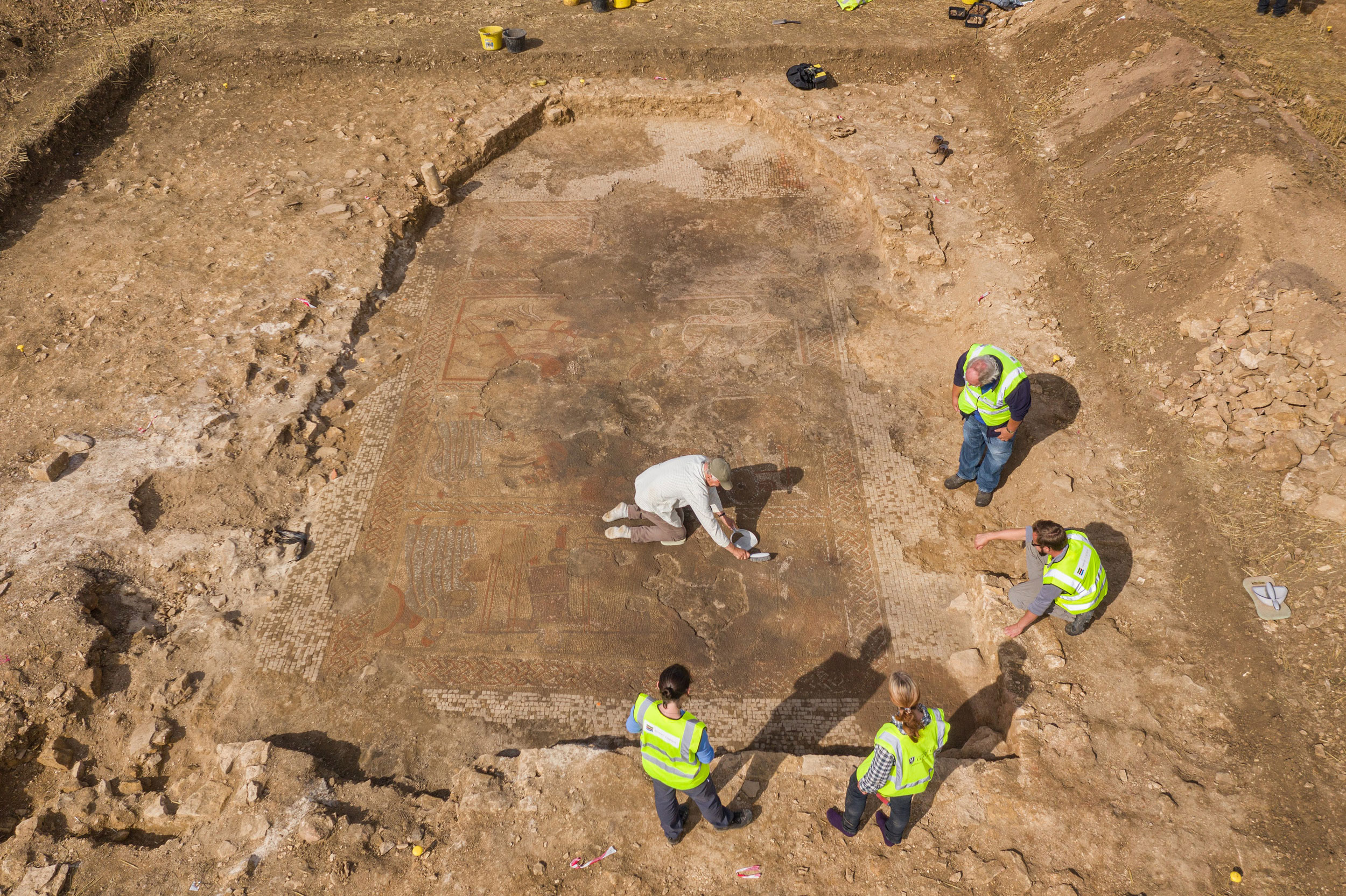 Aerial view of the site and archaeologists at work.