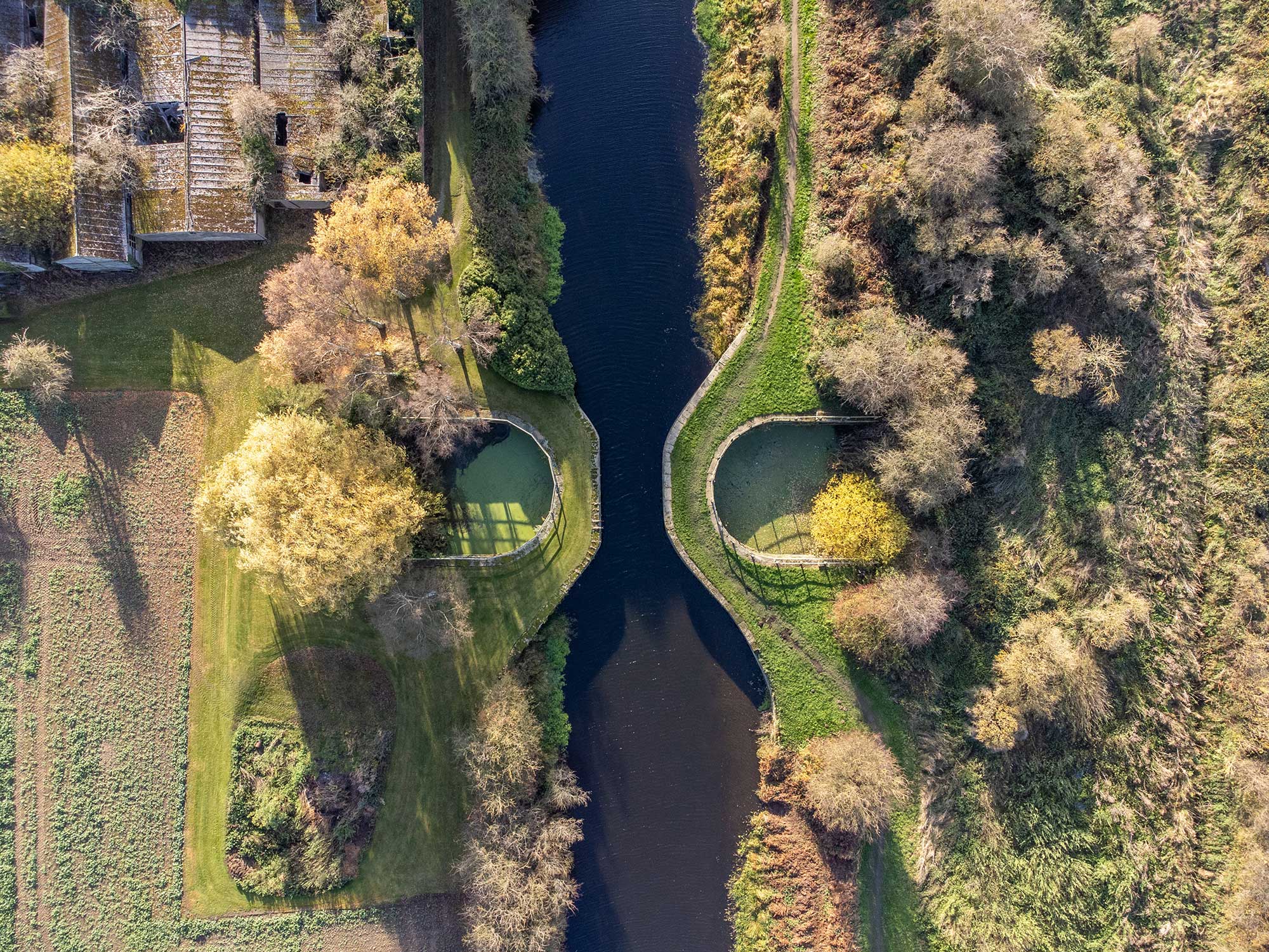 A pair of roughly D-shaped collection ponds either side of the canal channel